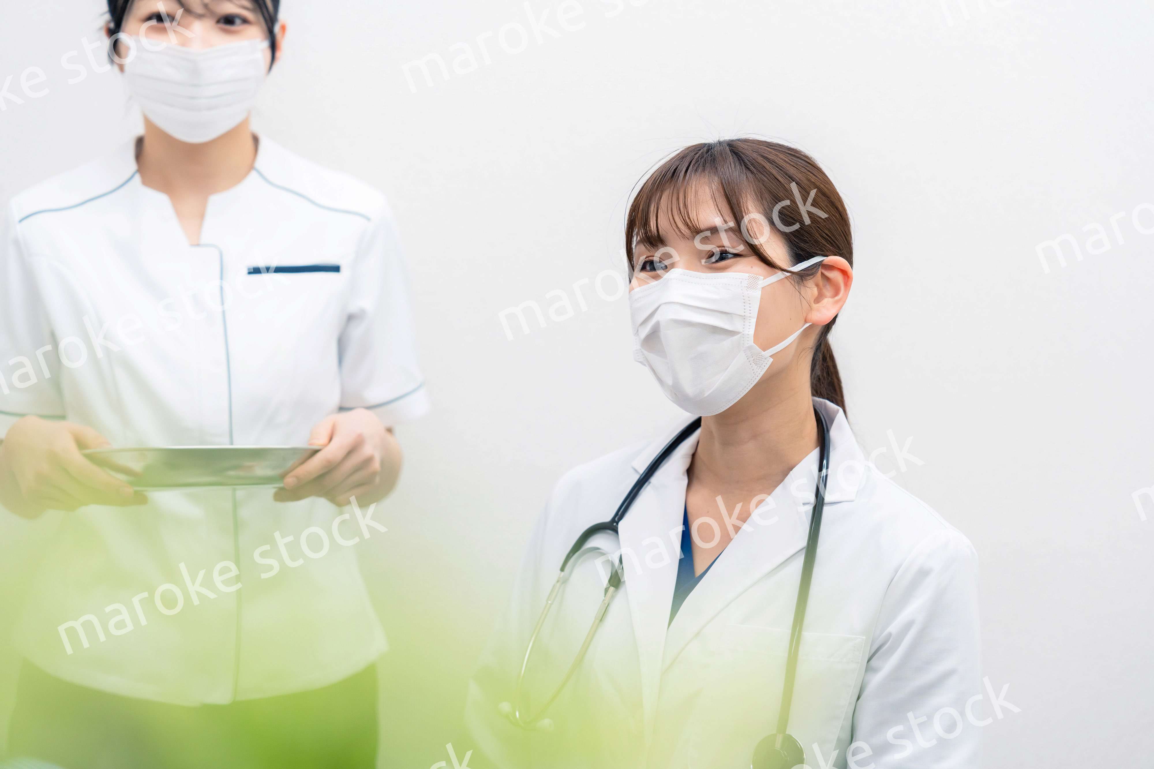 患者の治療をする2人の若い医療従事者