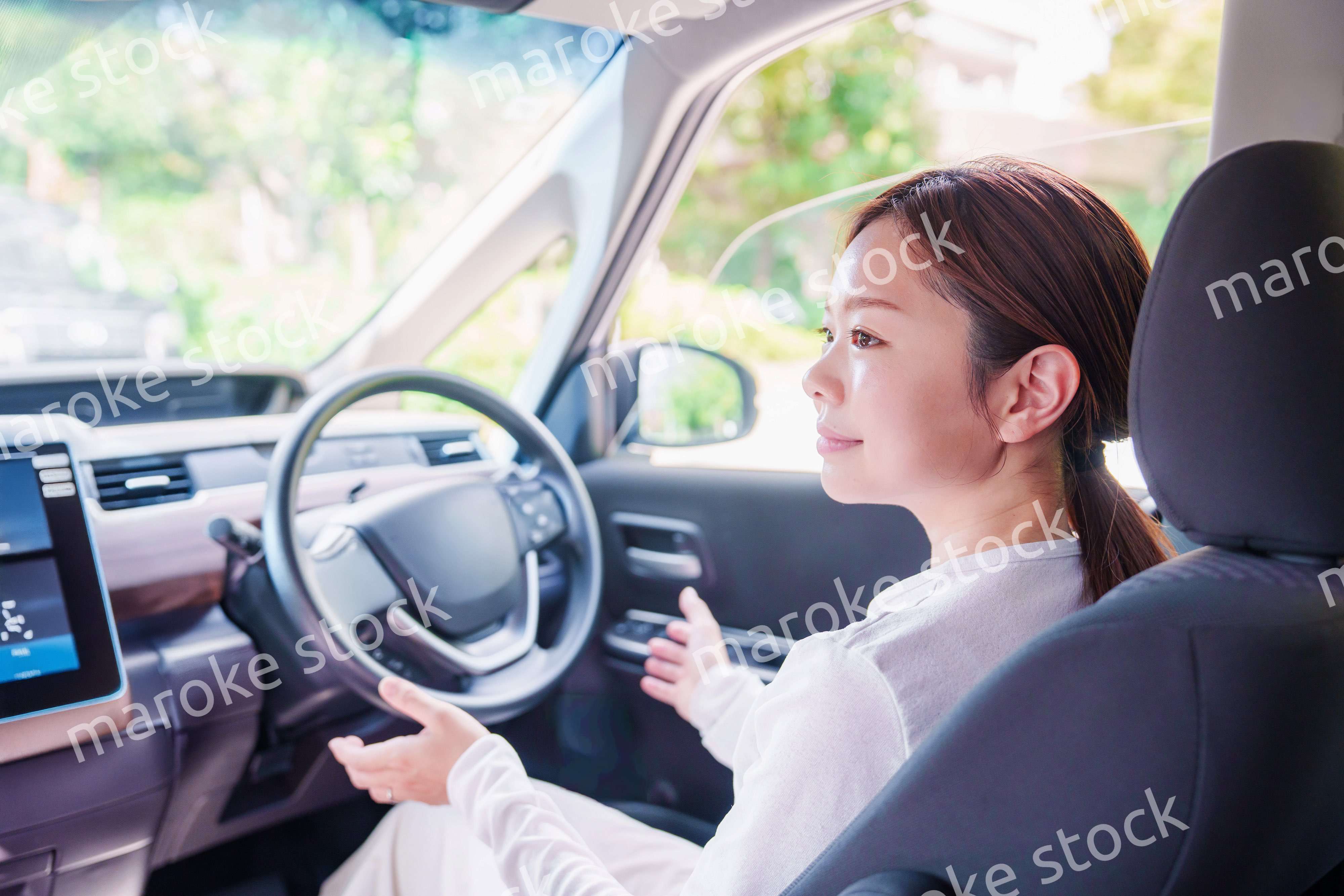自動運転の車を運転する若い女性