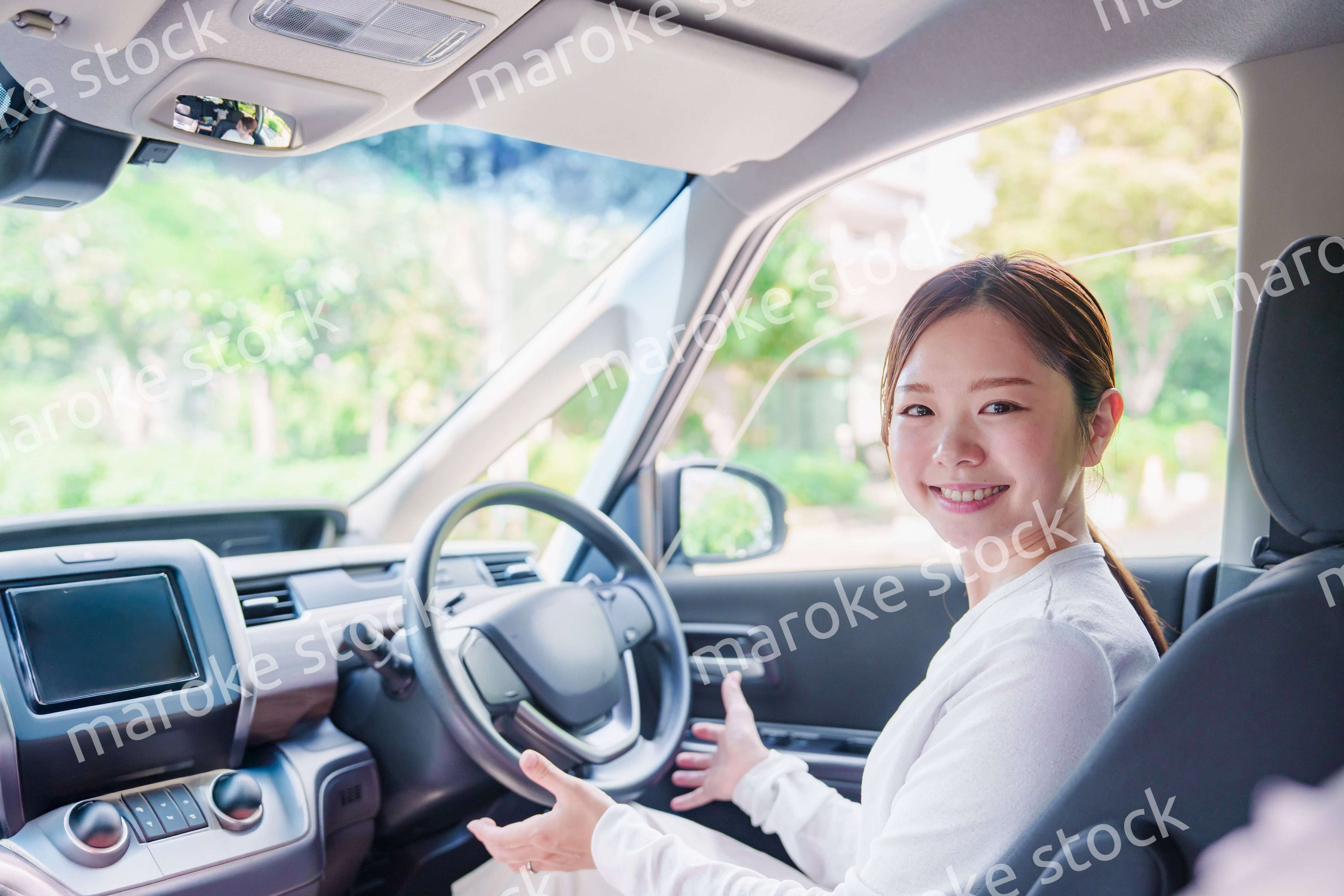 自動運転の車を笑顔で運転する女性