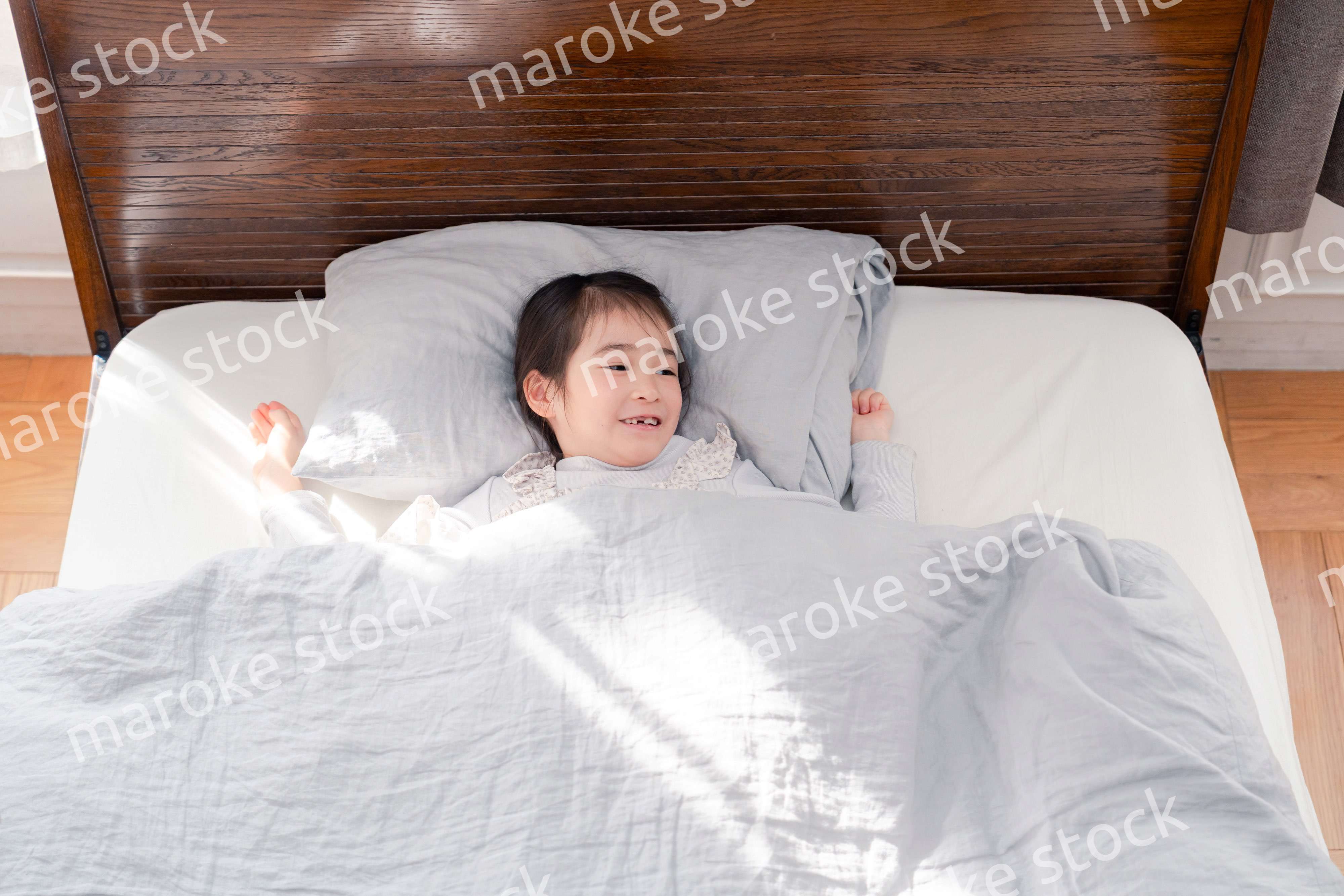 ベッドでぐっすりと寝る小さな女の子