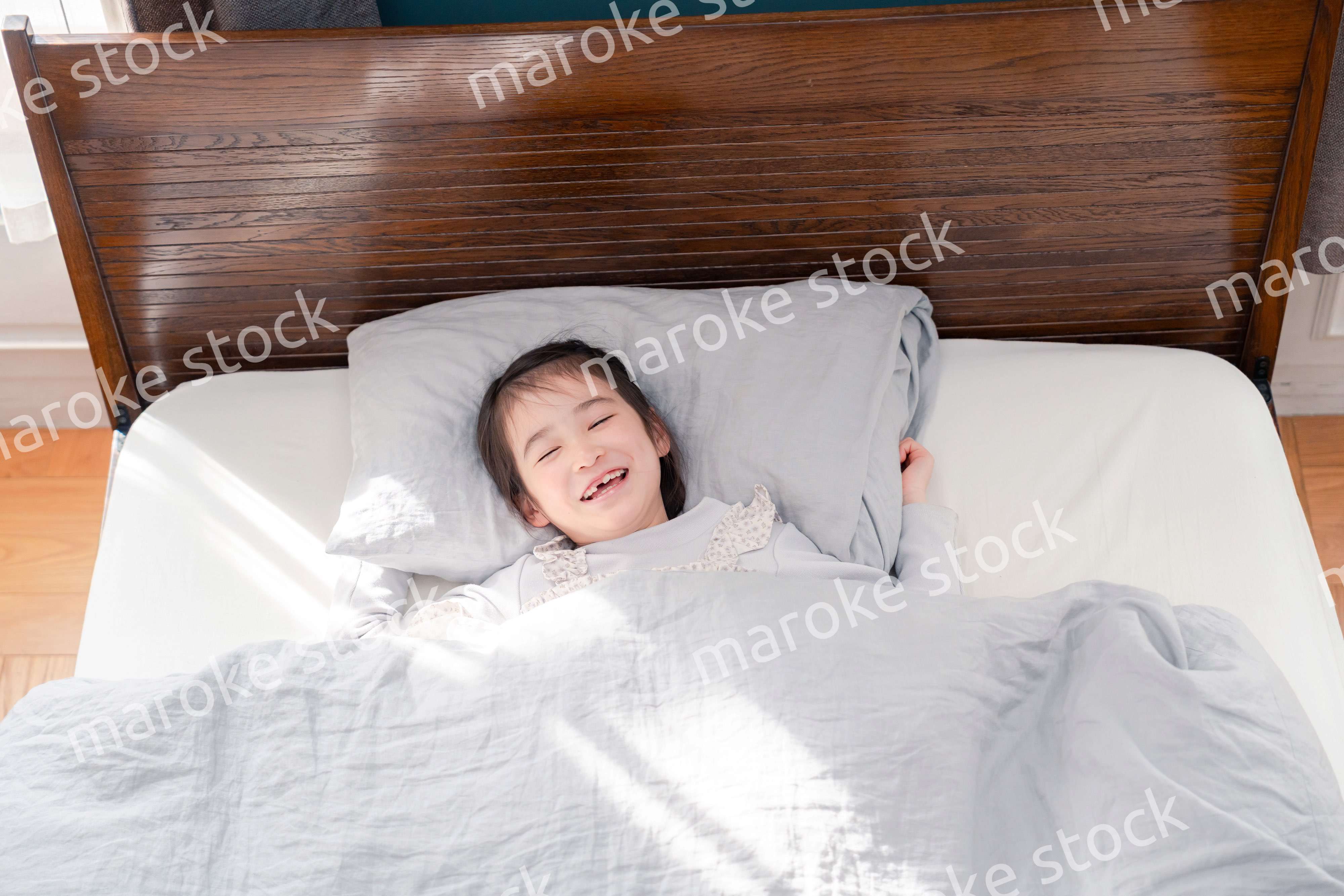 ベッドでぐっすりと寝る小さな女の子