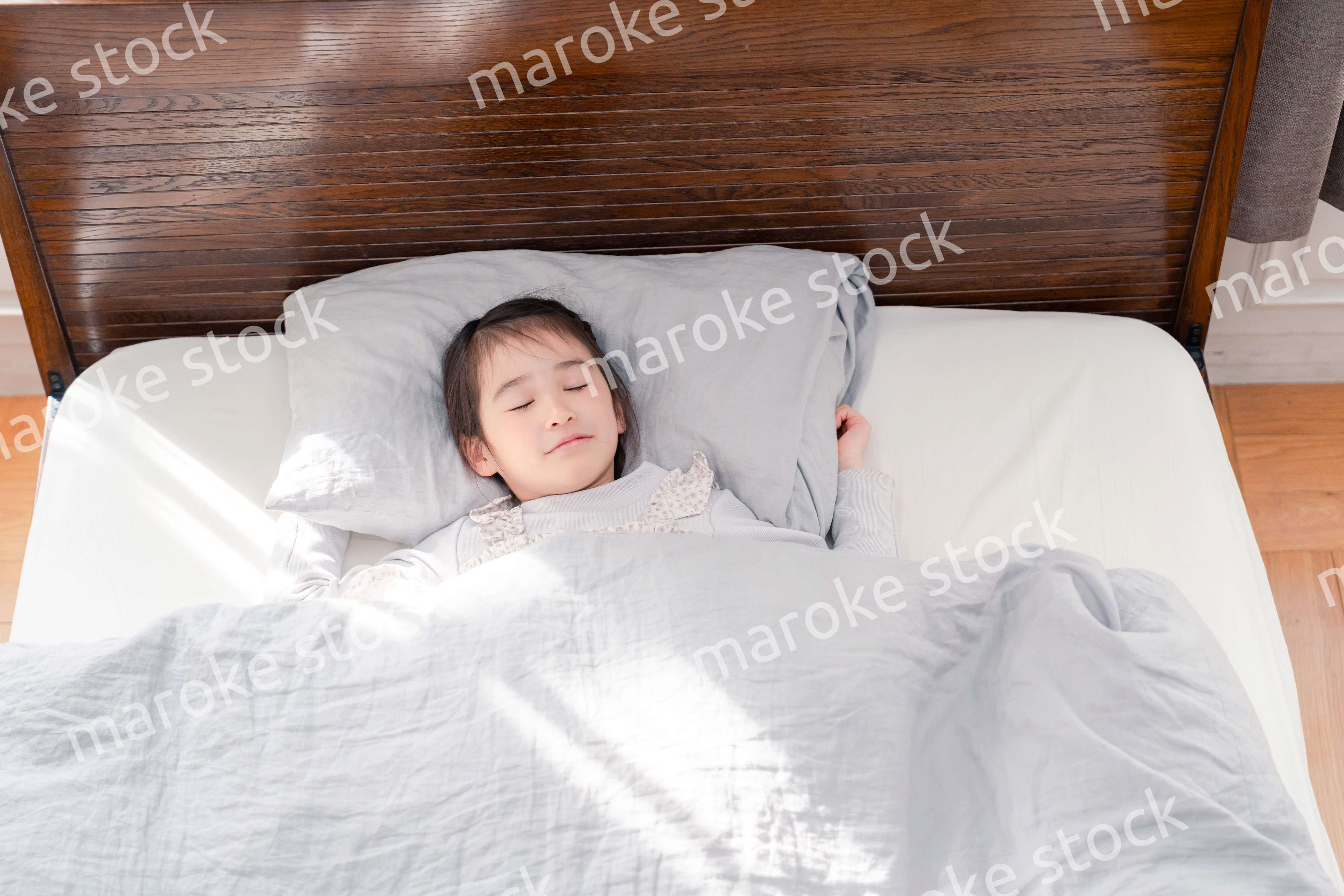 ベッドでぐっすりと寝る小さな女の子
