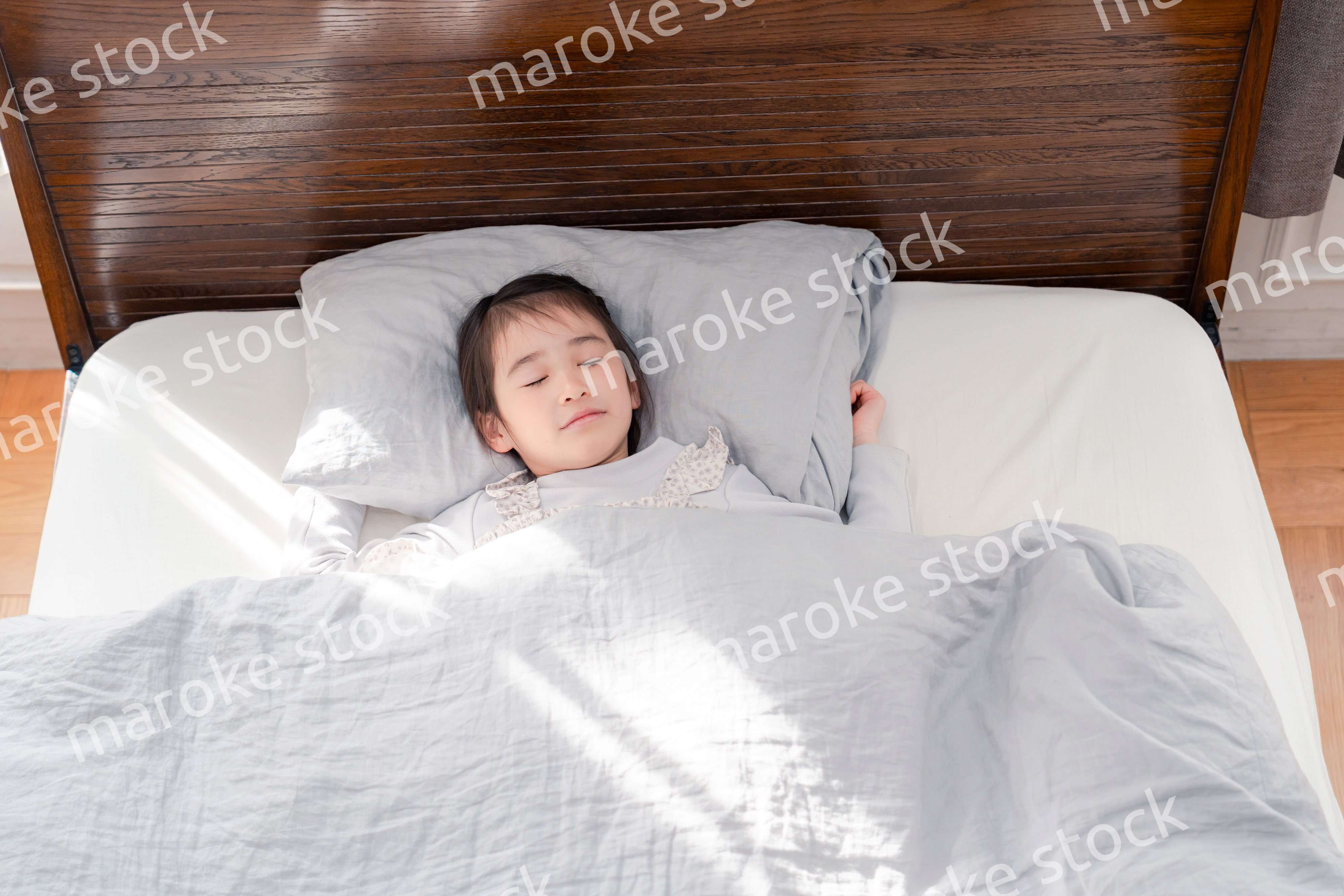 ベッドでぐっすりと寝る小さな女の子