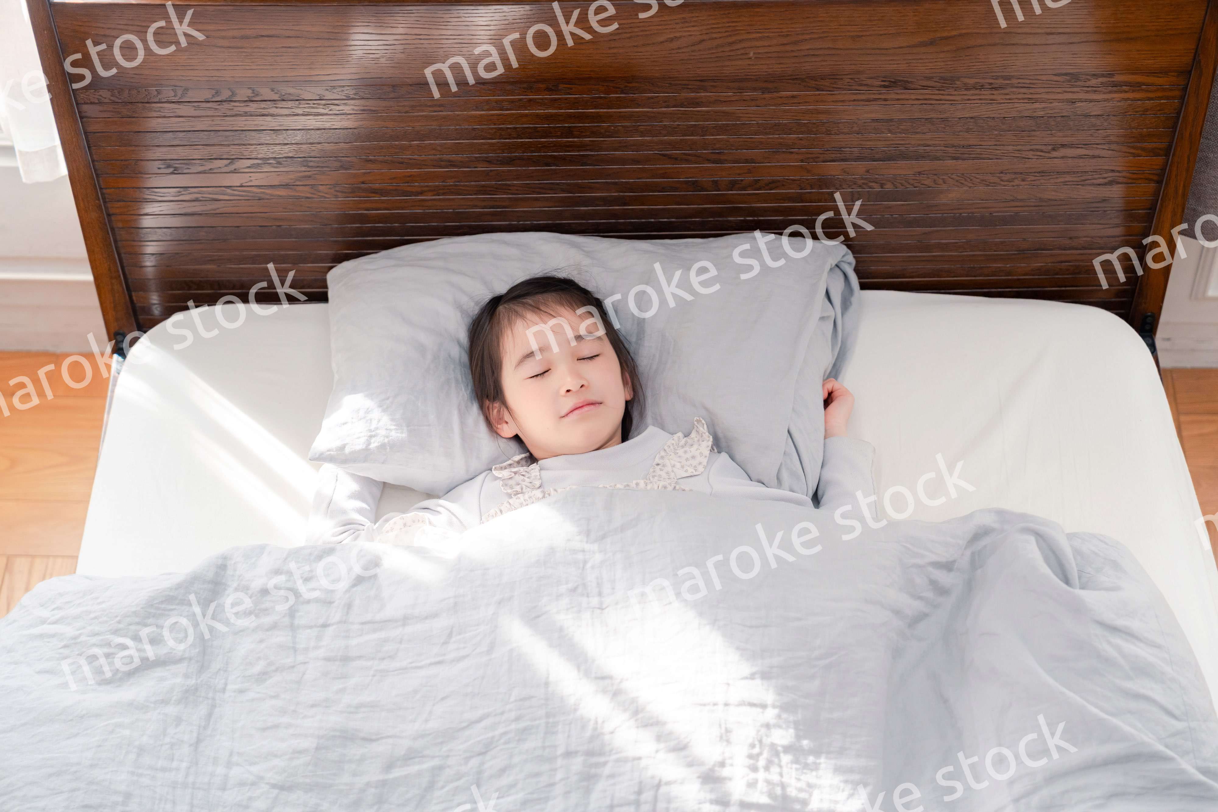 ベッドでぐっすりと寝る小さな女の子