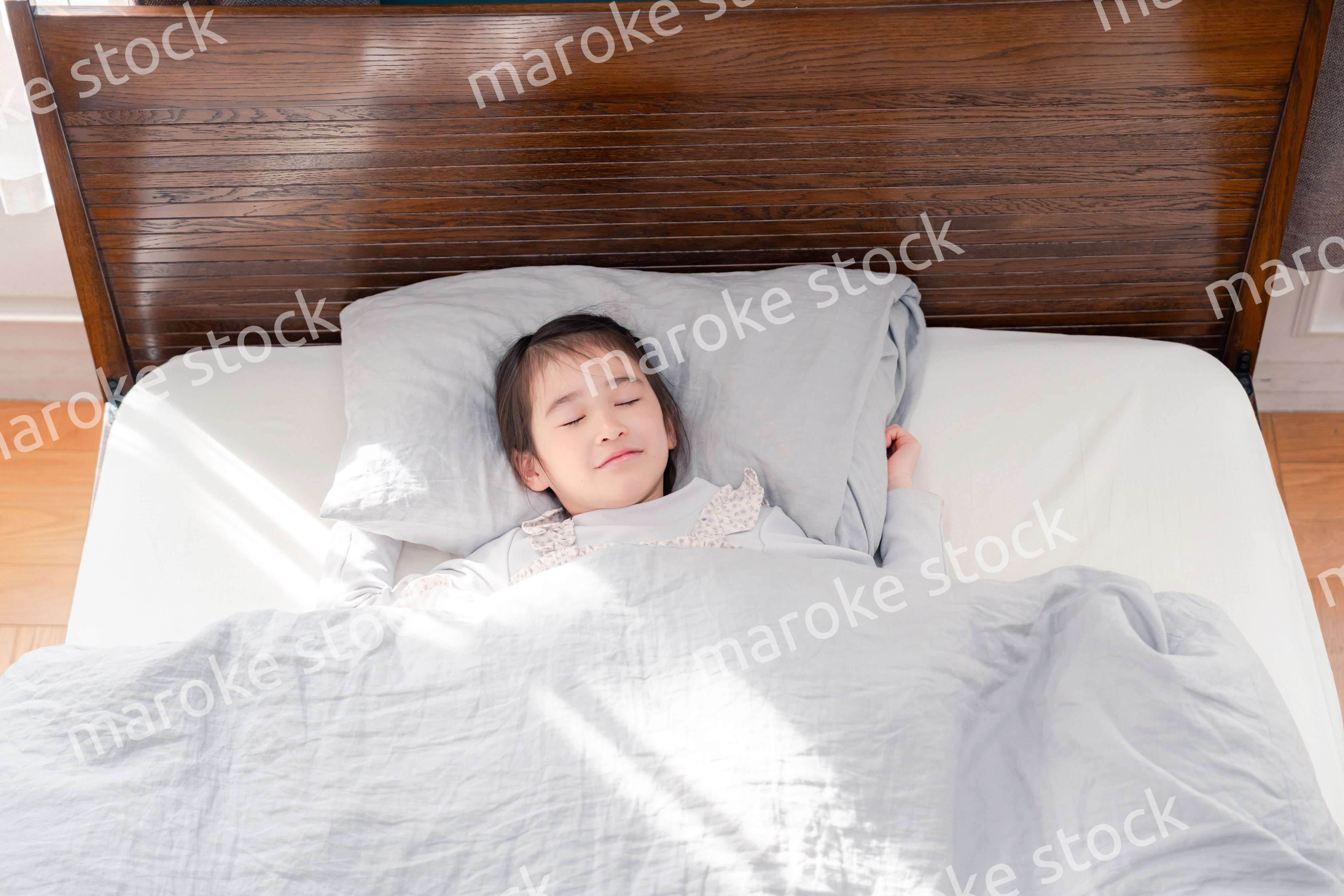 ベッドでぐっすりと寝る小さな女の子