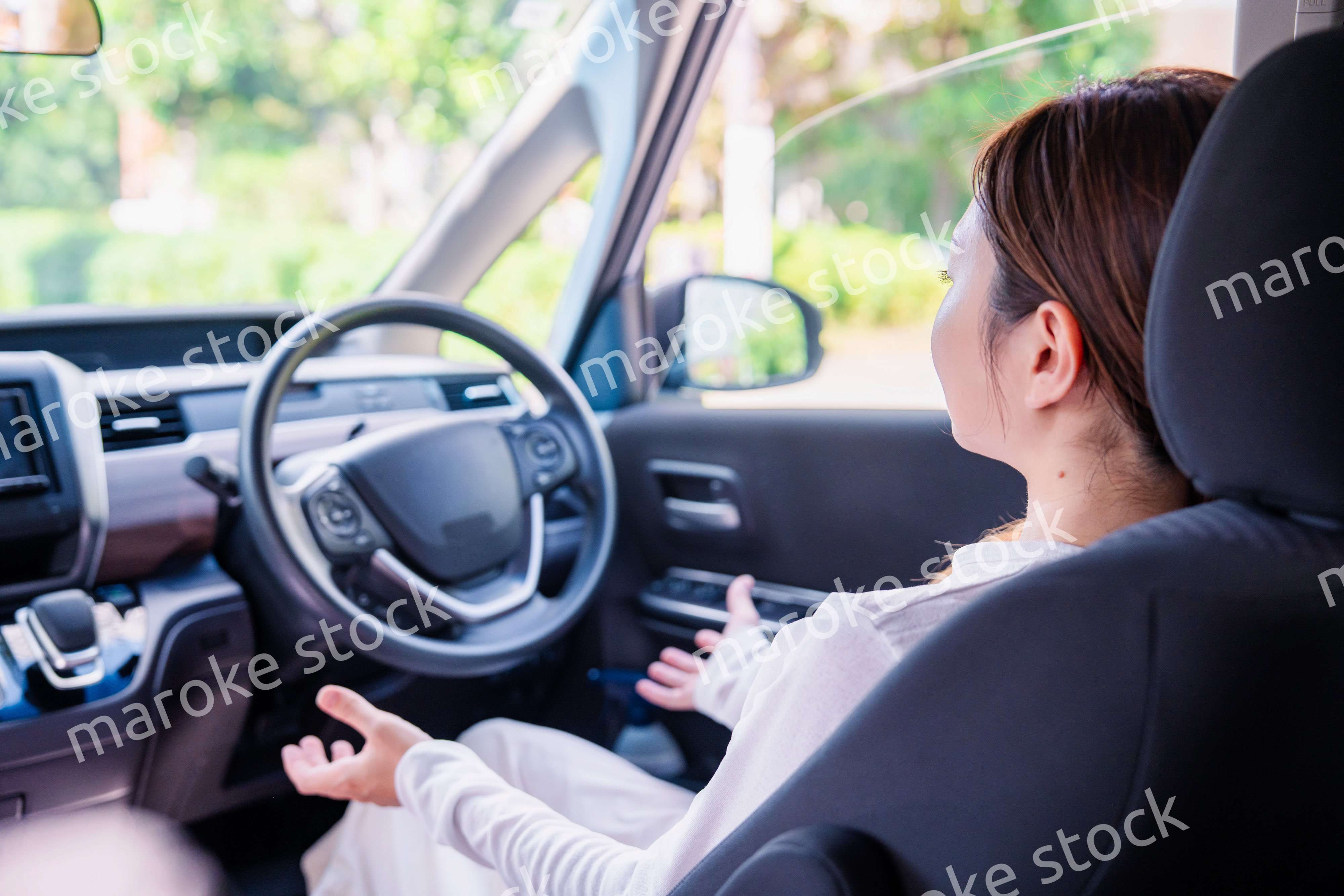 自動運転の車で手放し運転をする若い女性