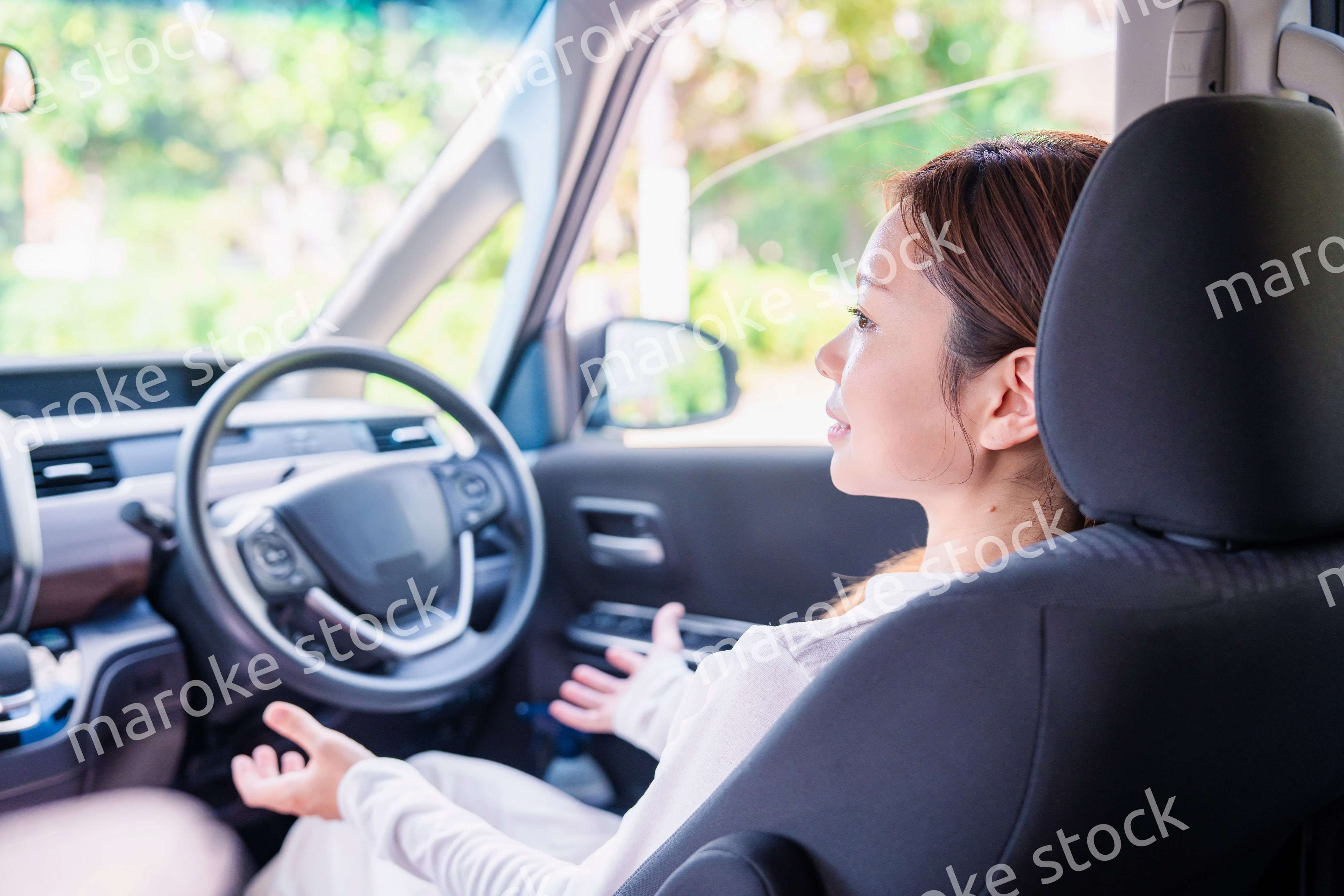 自動運転の車で手放し運転をする若い女性