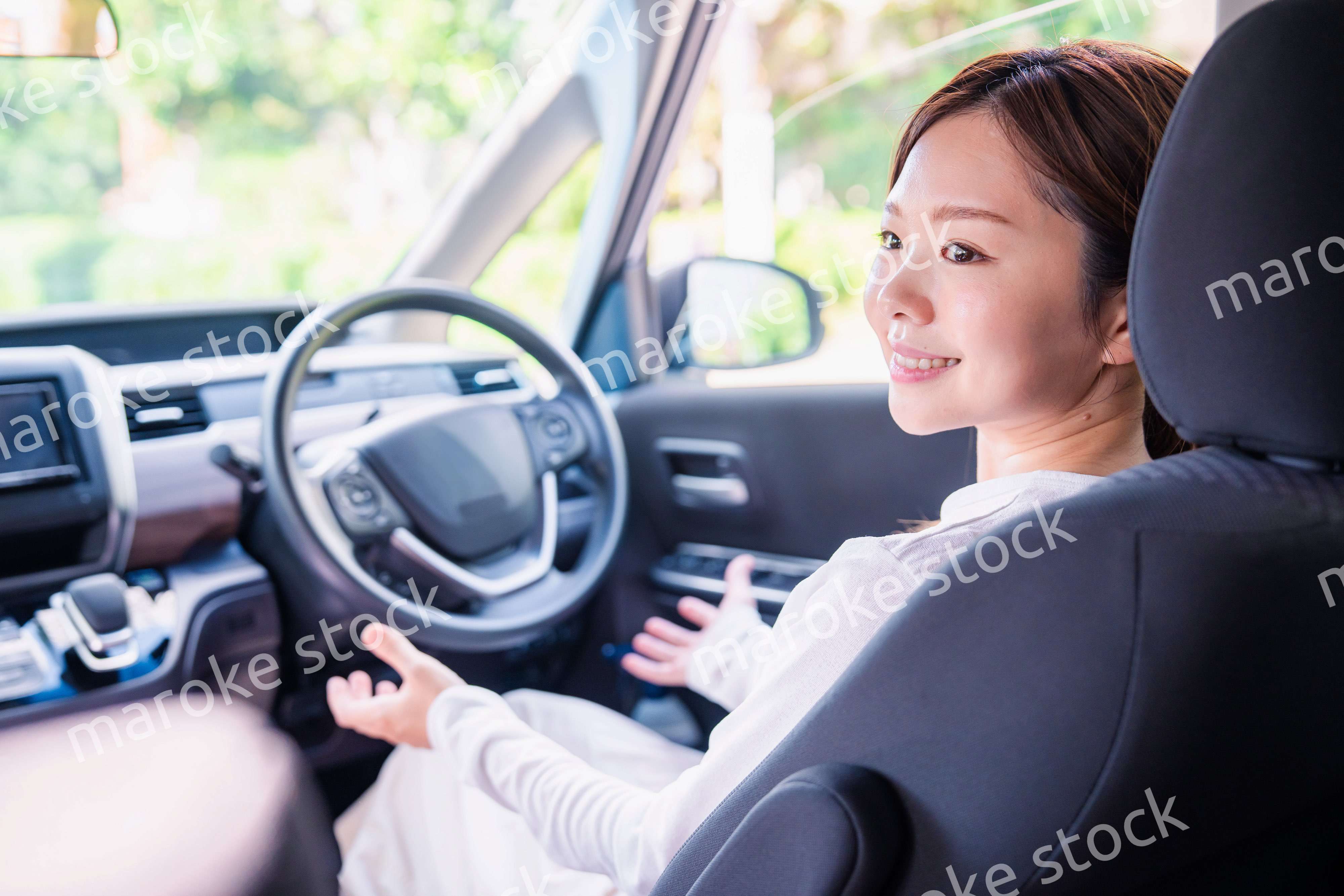 自動運転の車で手放し運転をする若い女性