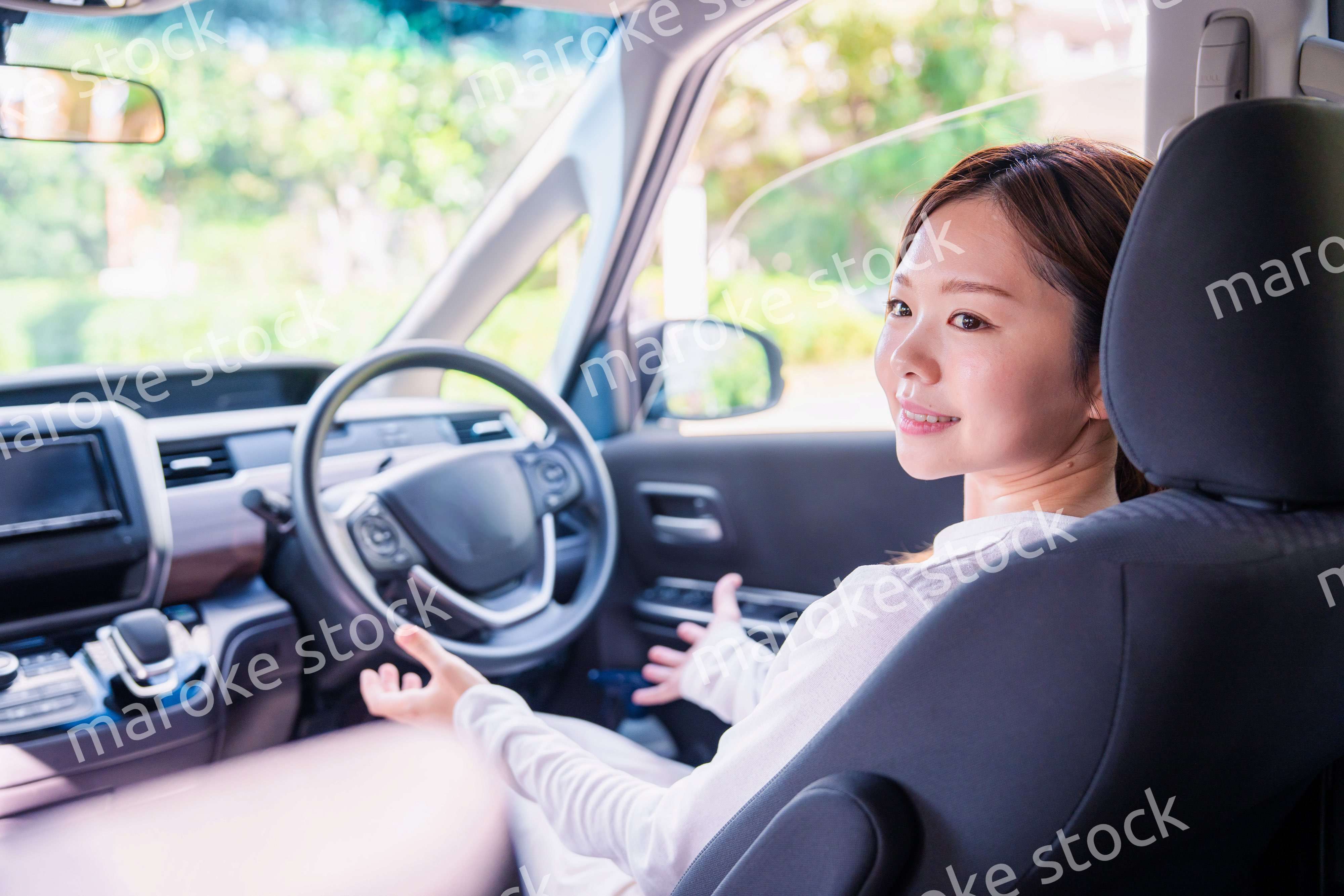 自動運転の車で手放し運転をする若い女性