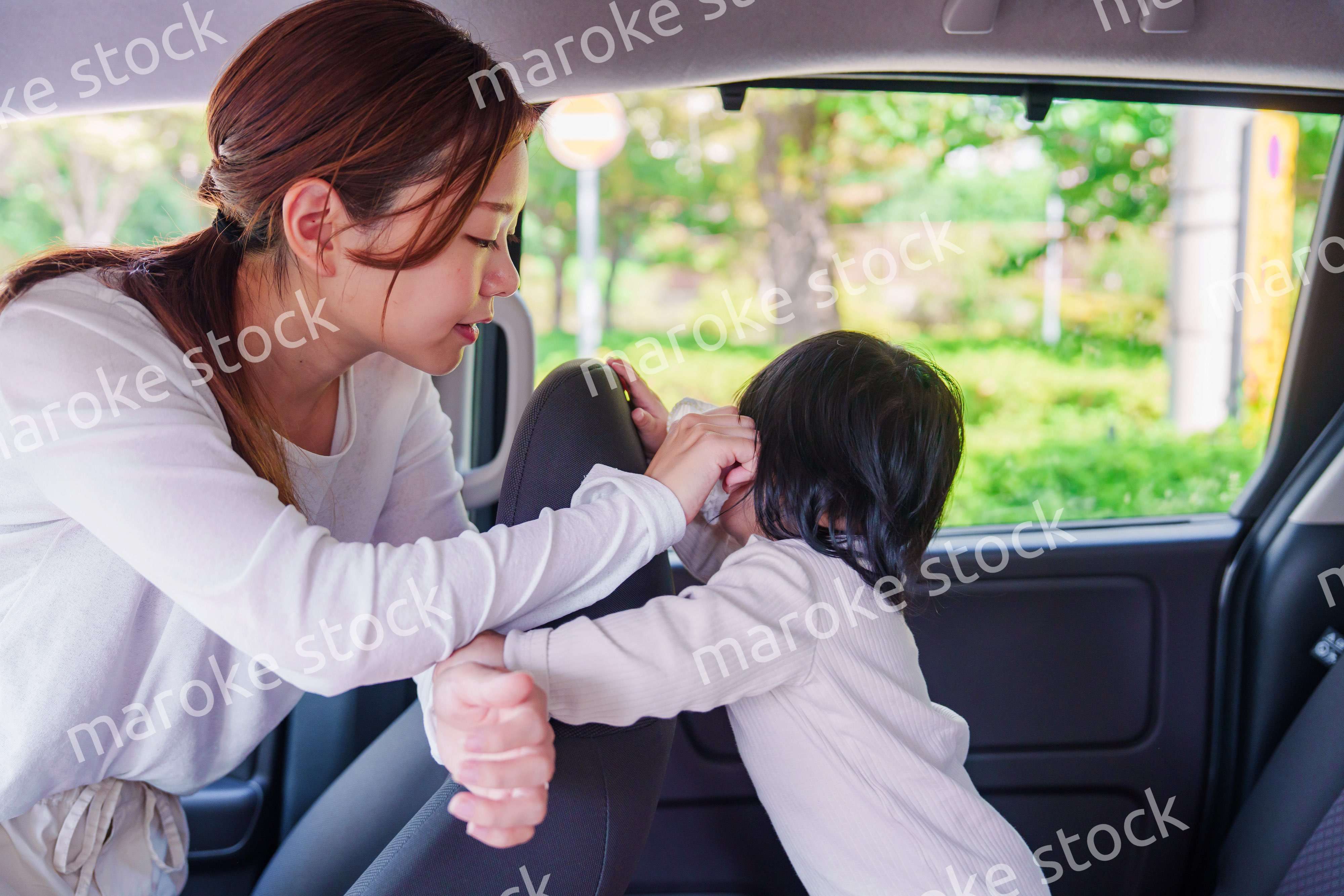 車に子供を乗せるお母さん