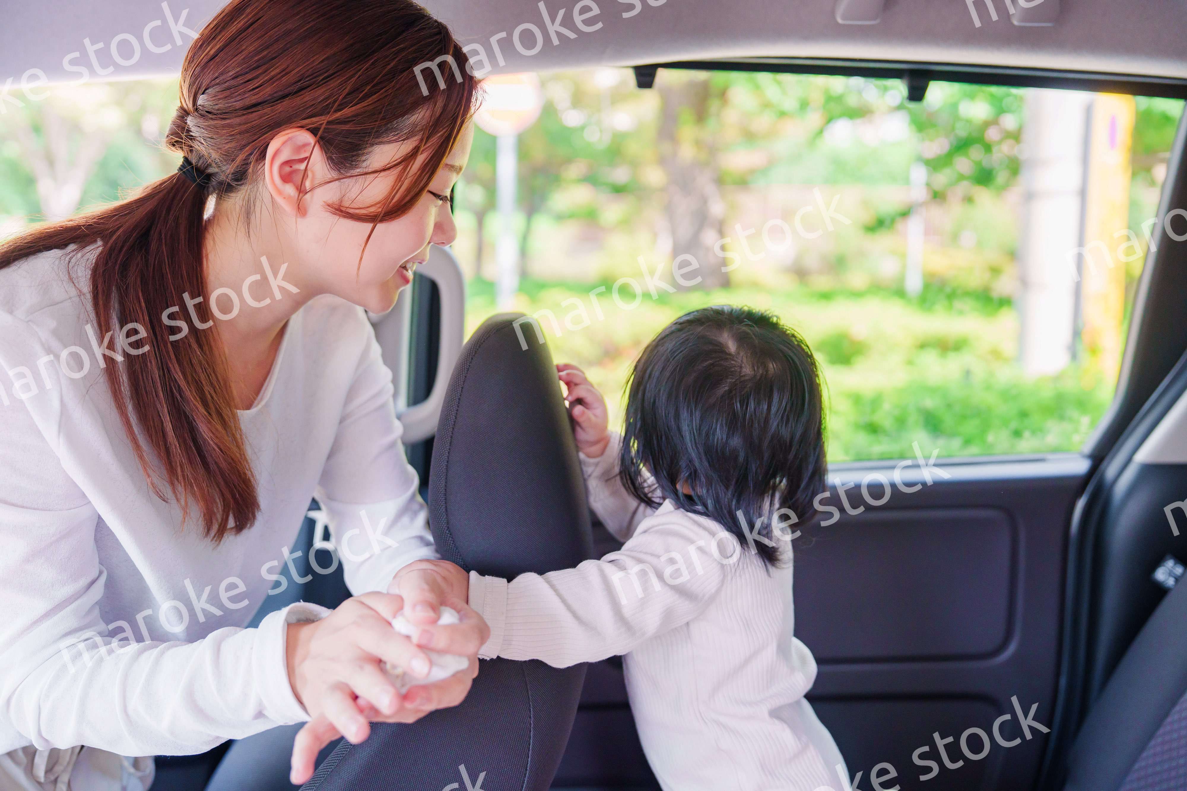 車に子供を乗せるお母さん
