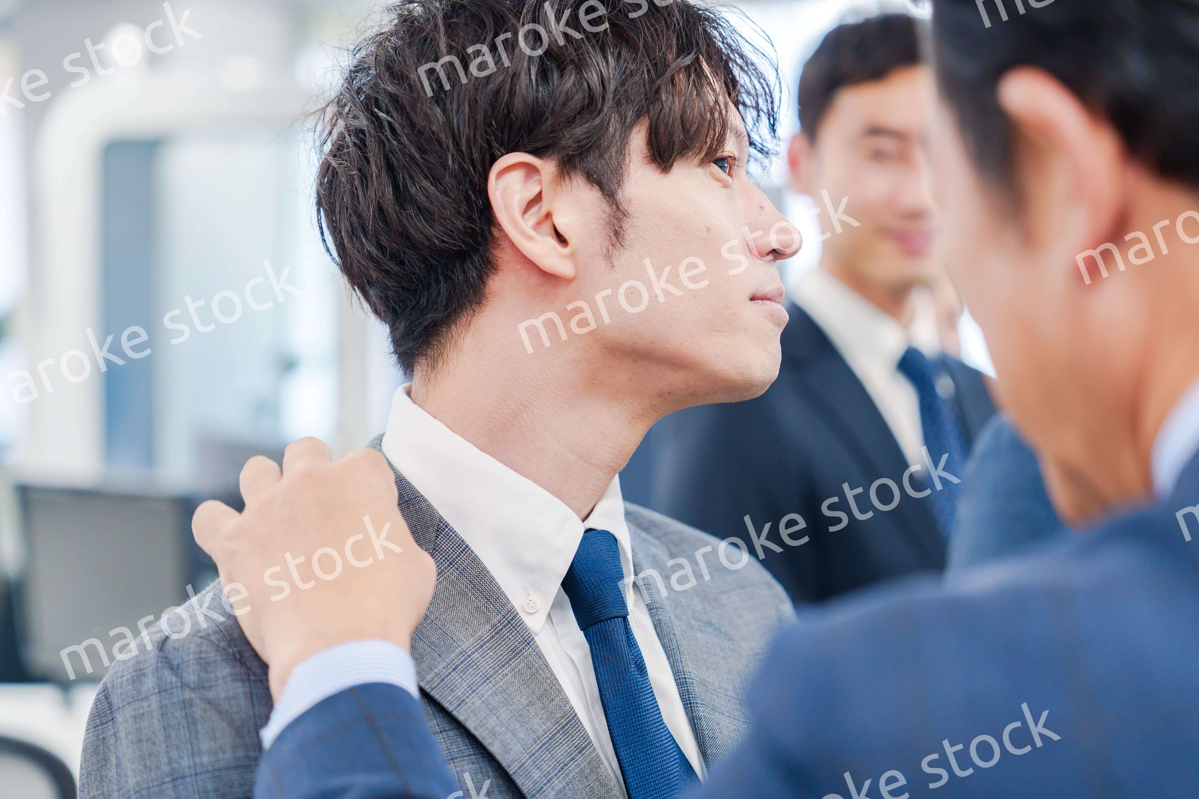 部下の身だしなみを整える上司