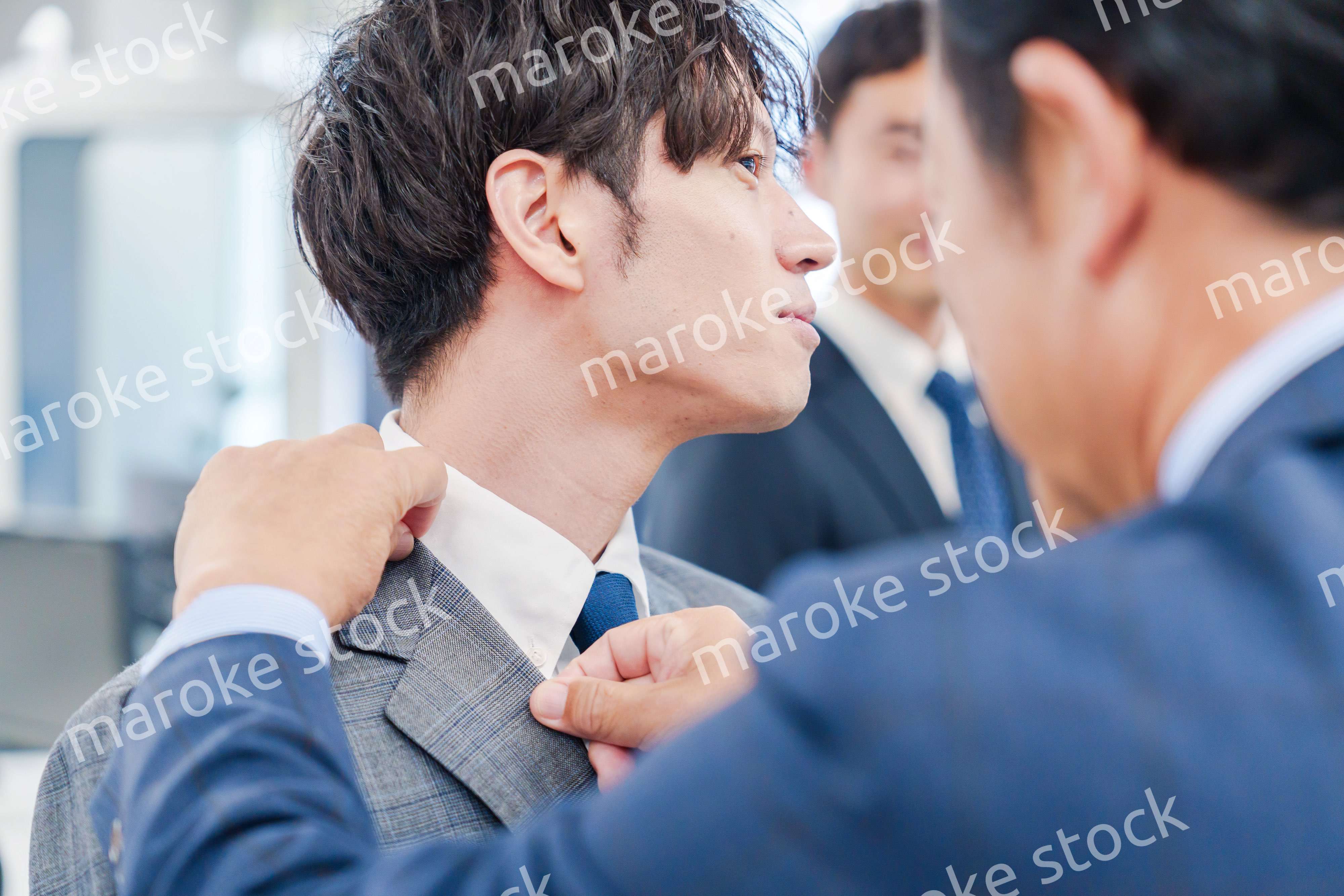 部下の身だしなみを整える上司