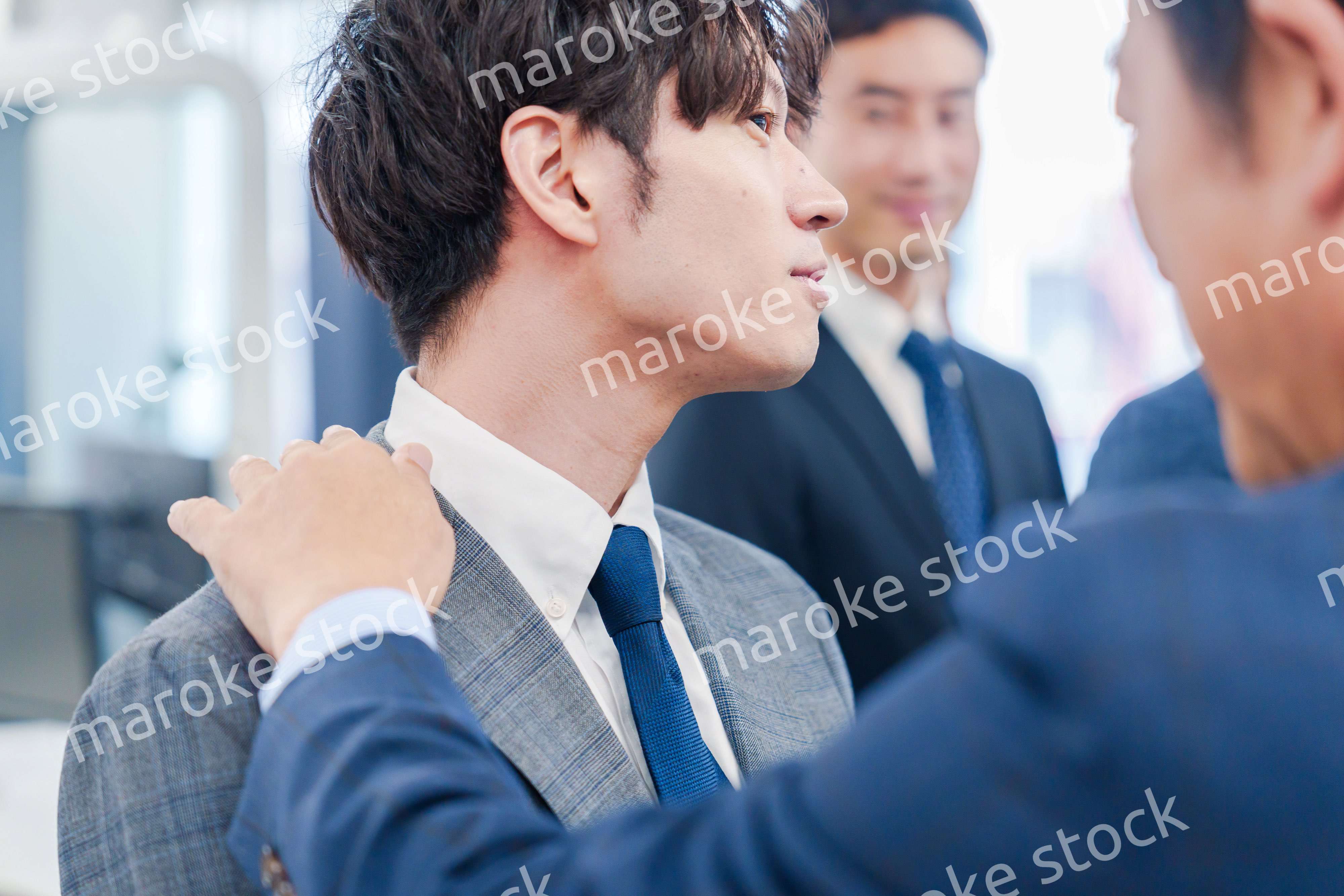 部下の身だしなみを整える上司