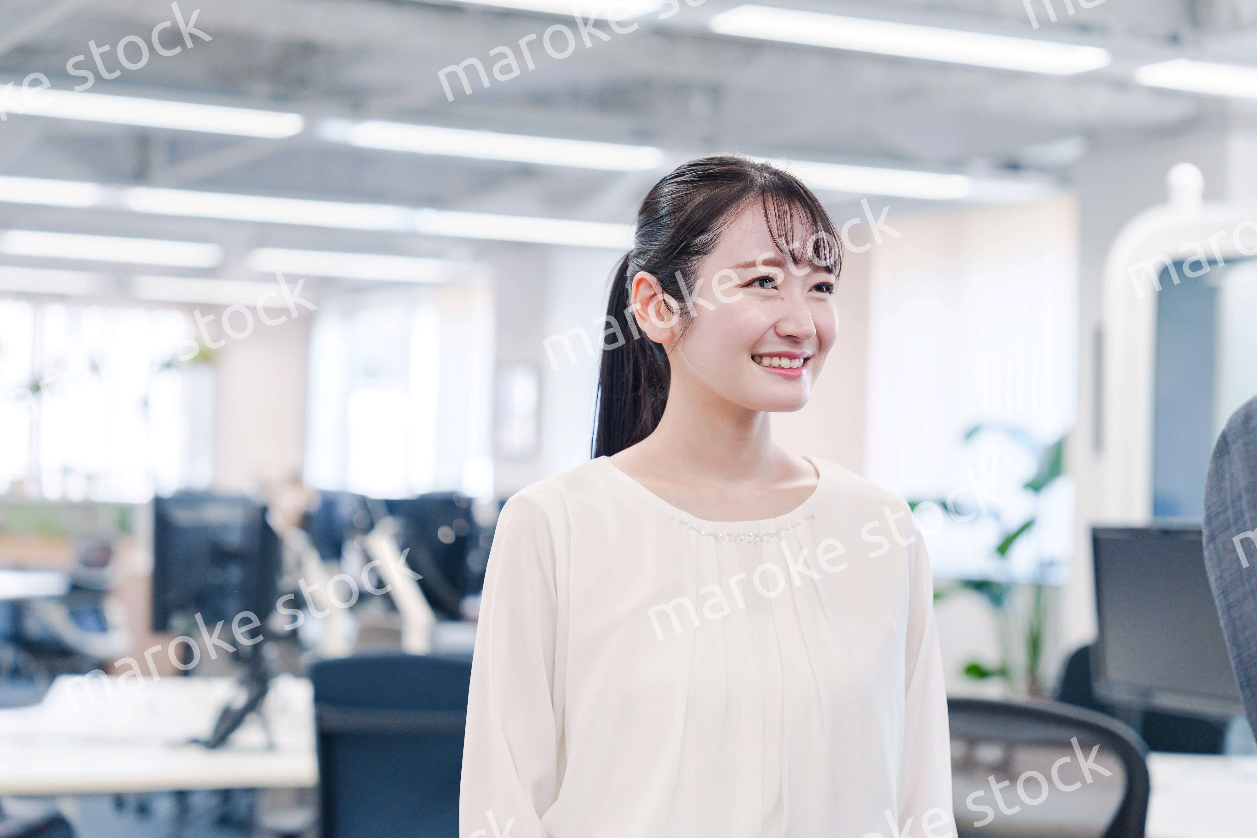 オフィスで楽しく働く若いキャリアウーマン