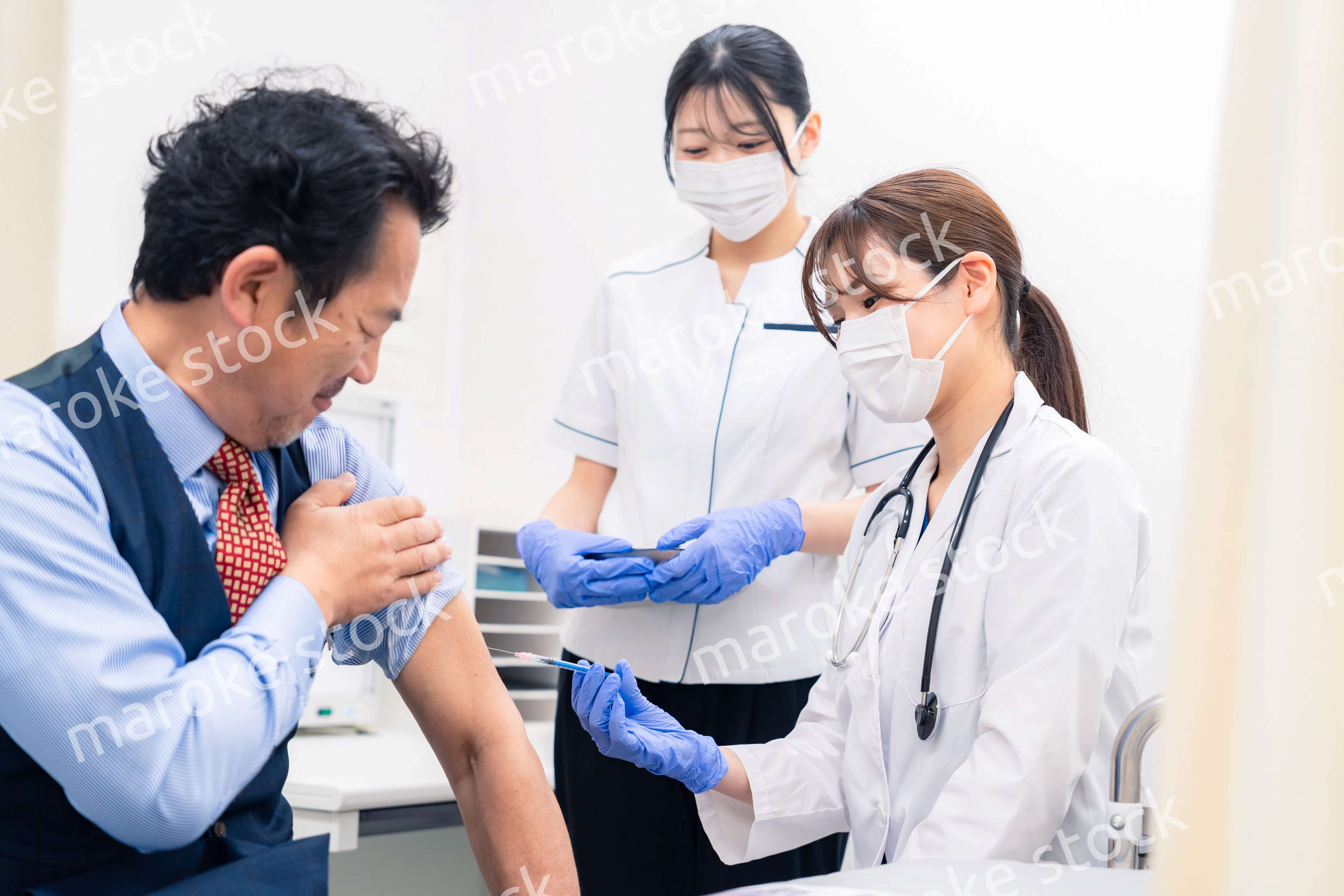 ワクチン接種・採血をする医療従事者の女性