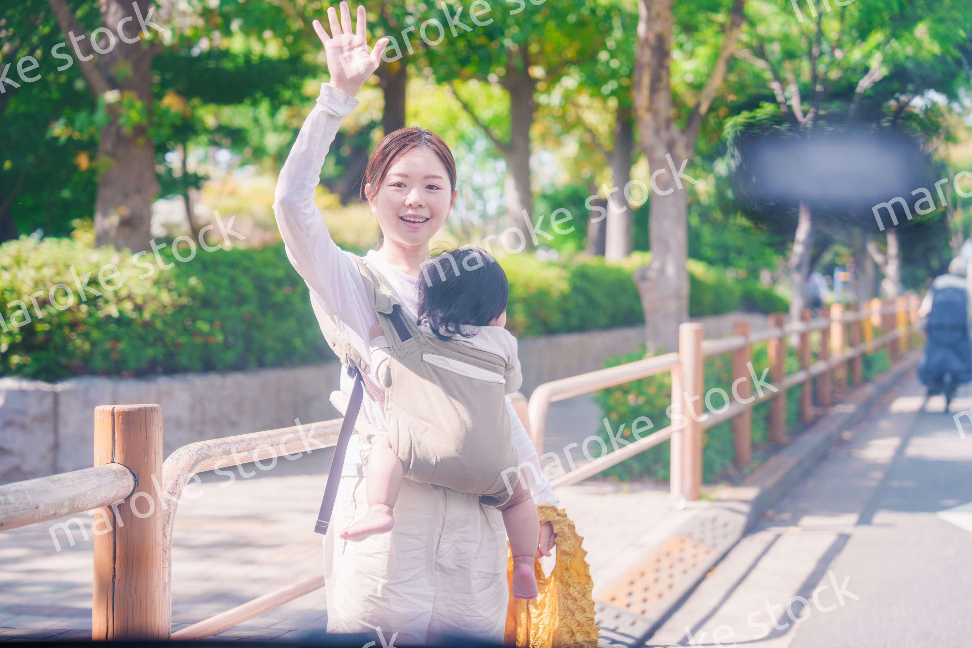 流しのタクシーを止める抱っこ紐をした女性