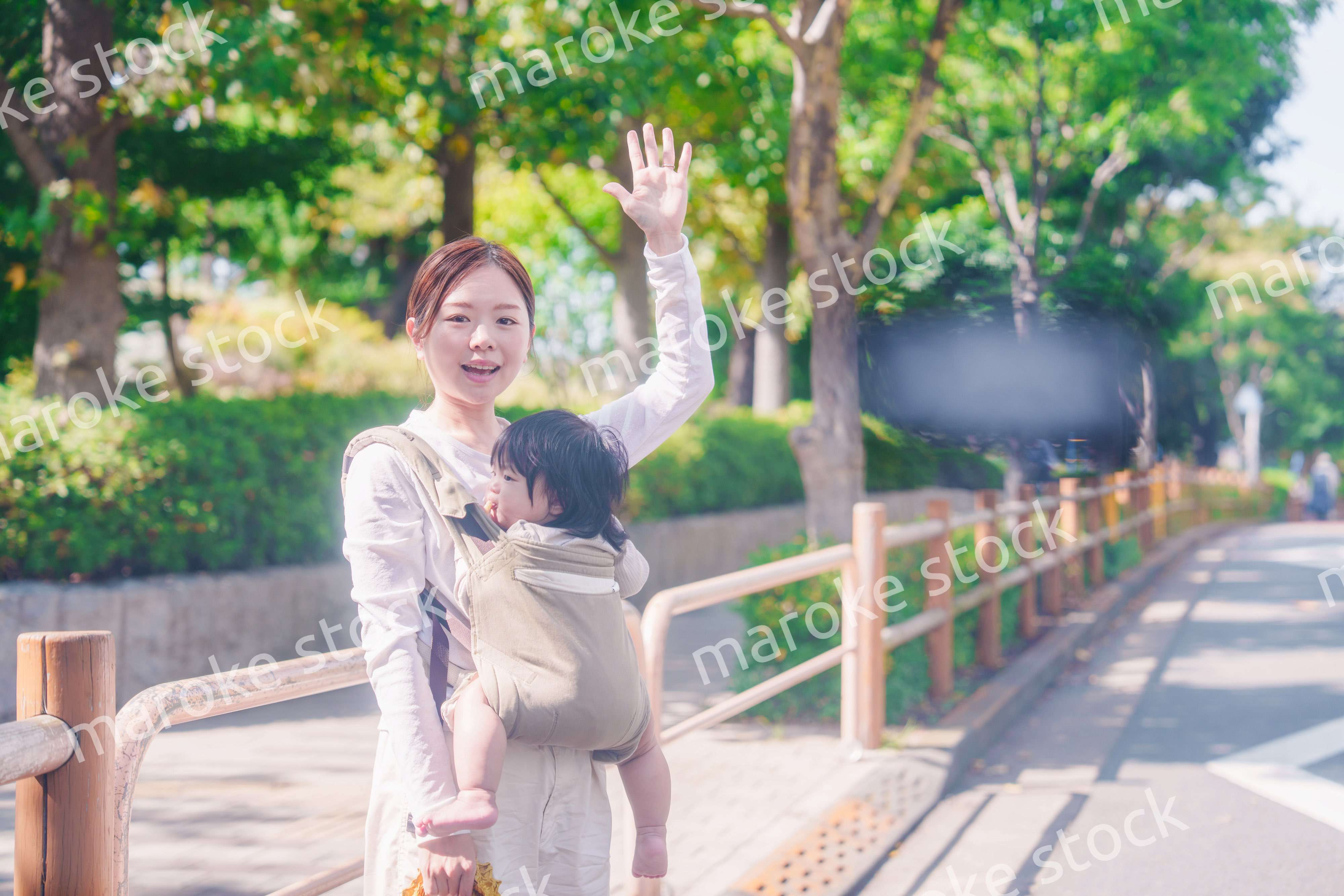 流しのタクシーを止める抱っこ紐をした女性