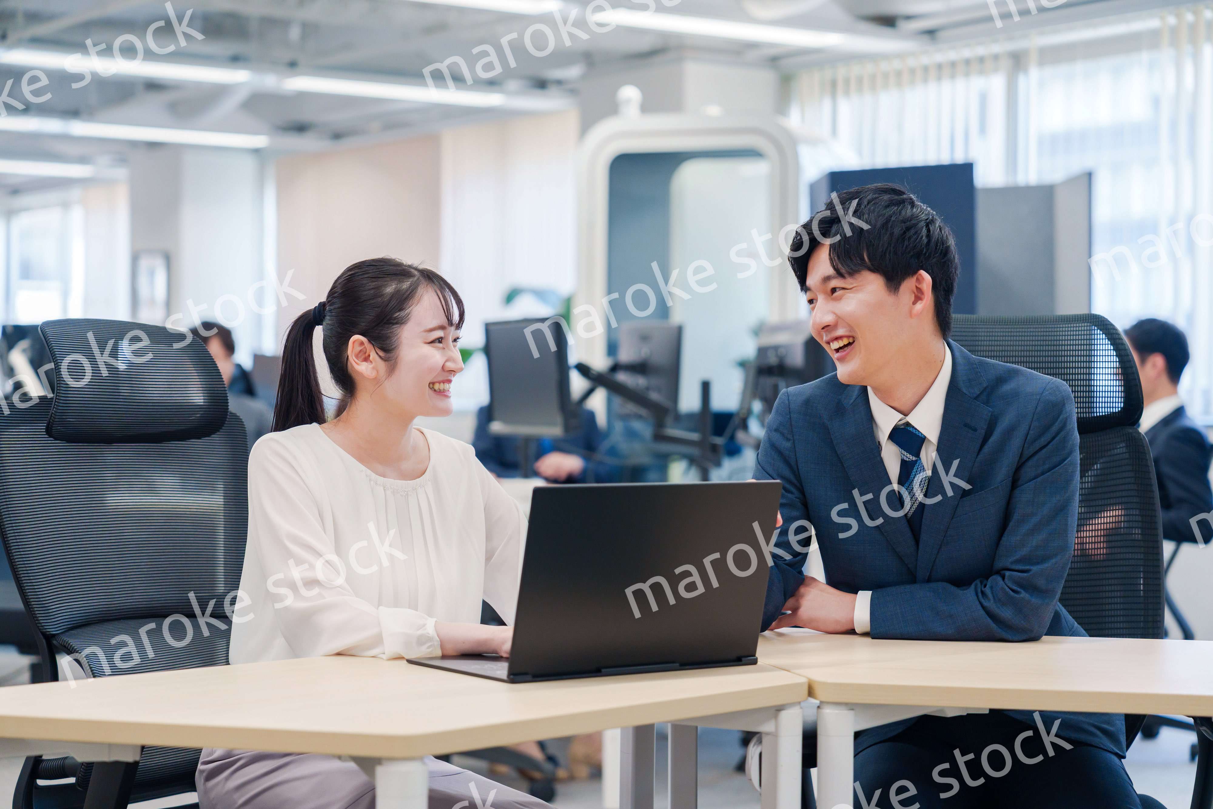 先輩社員から業務を教えてもらう新人の女性