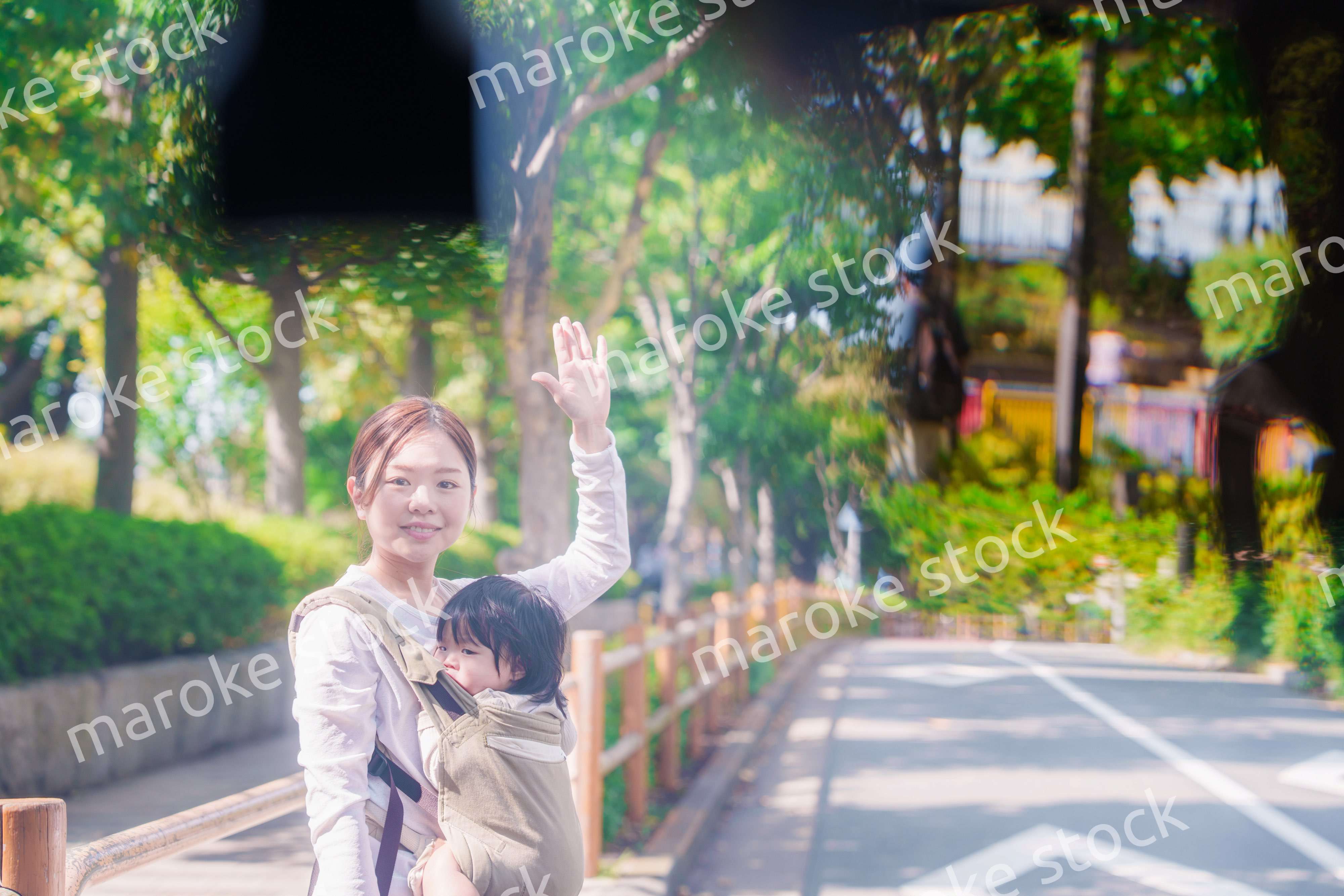 流しのタクシーを止める抱っこ紐をした女性