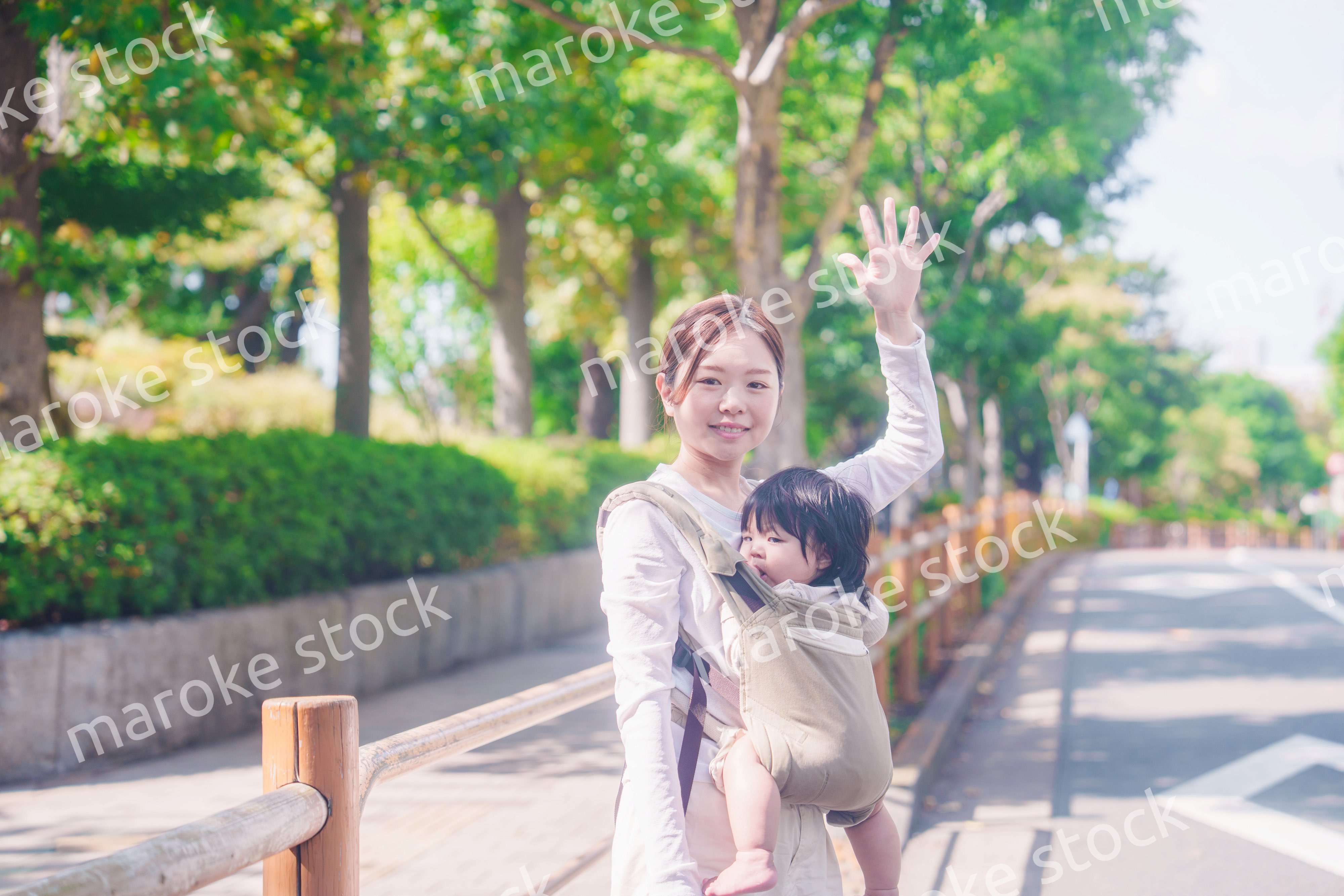 流しのタクシーを止める抱っこ紐をした女性