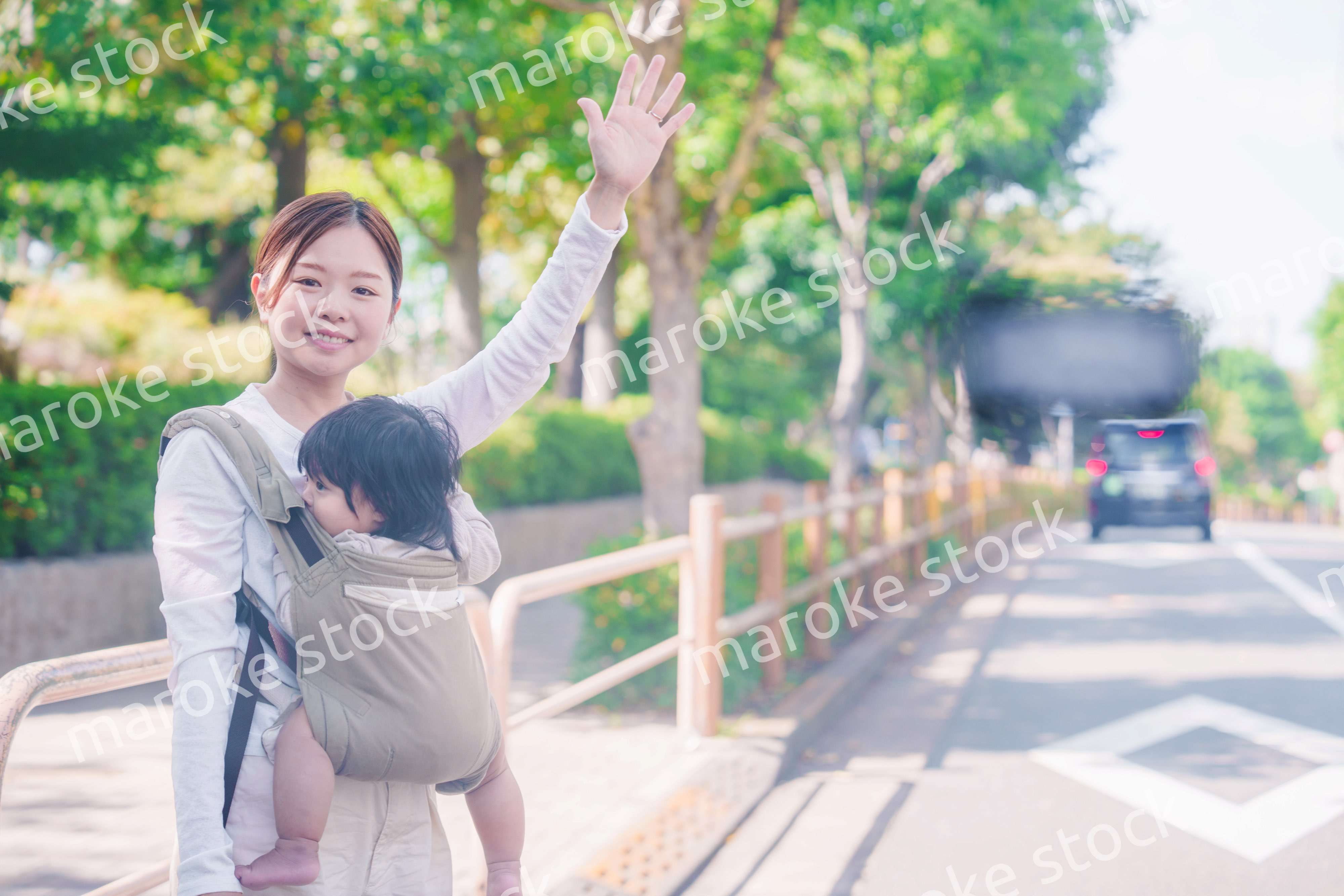 流しのタクシーを止める抱っこ紐をした女性