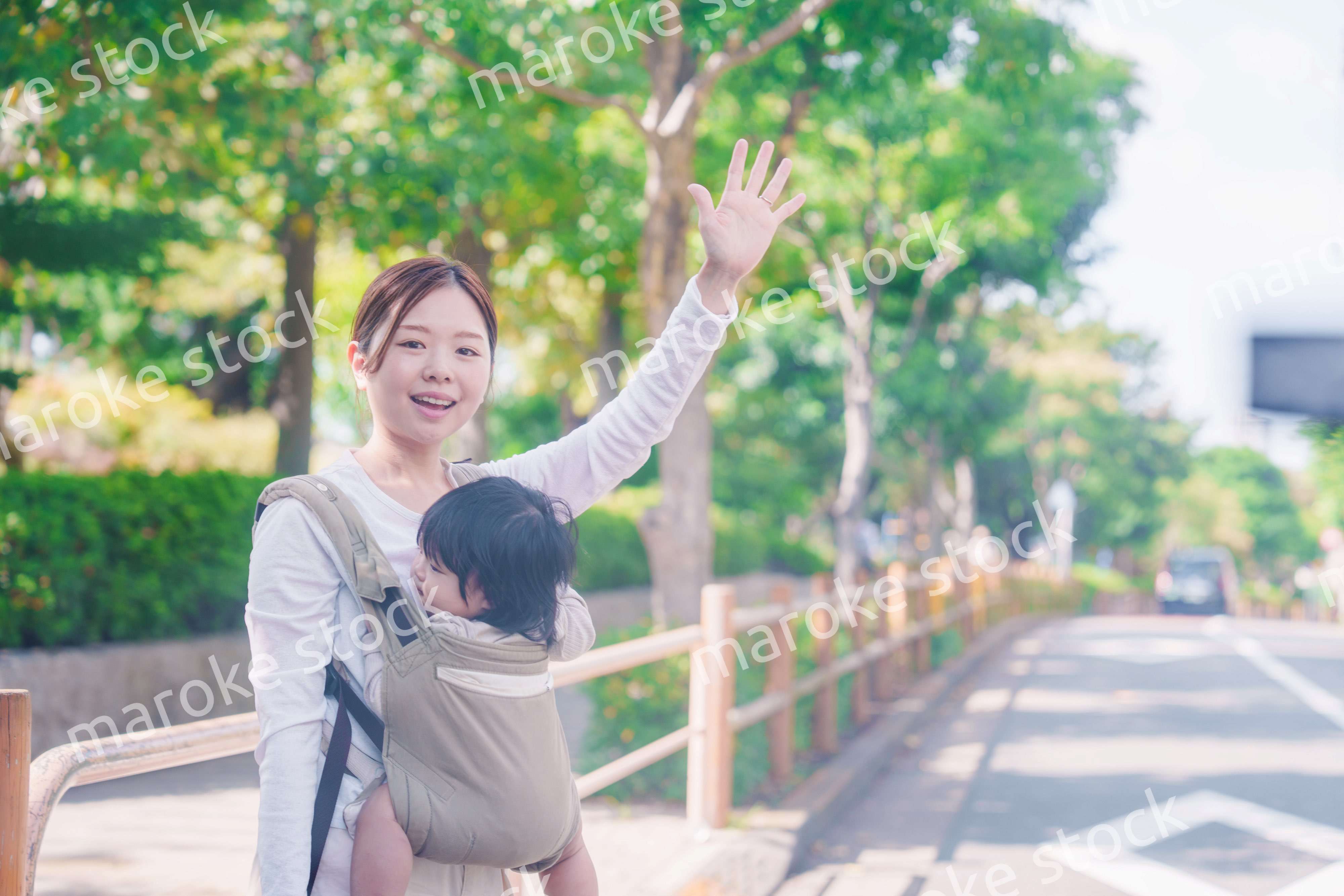 流しのタクシーを止める抱っこ紐をした女性