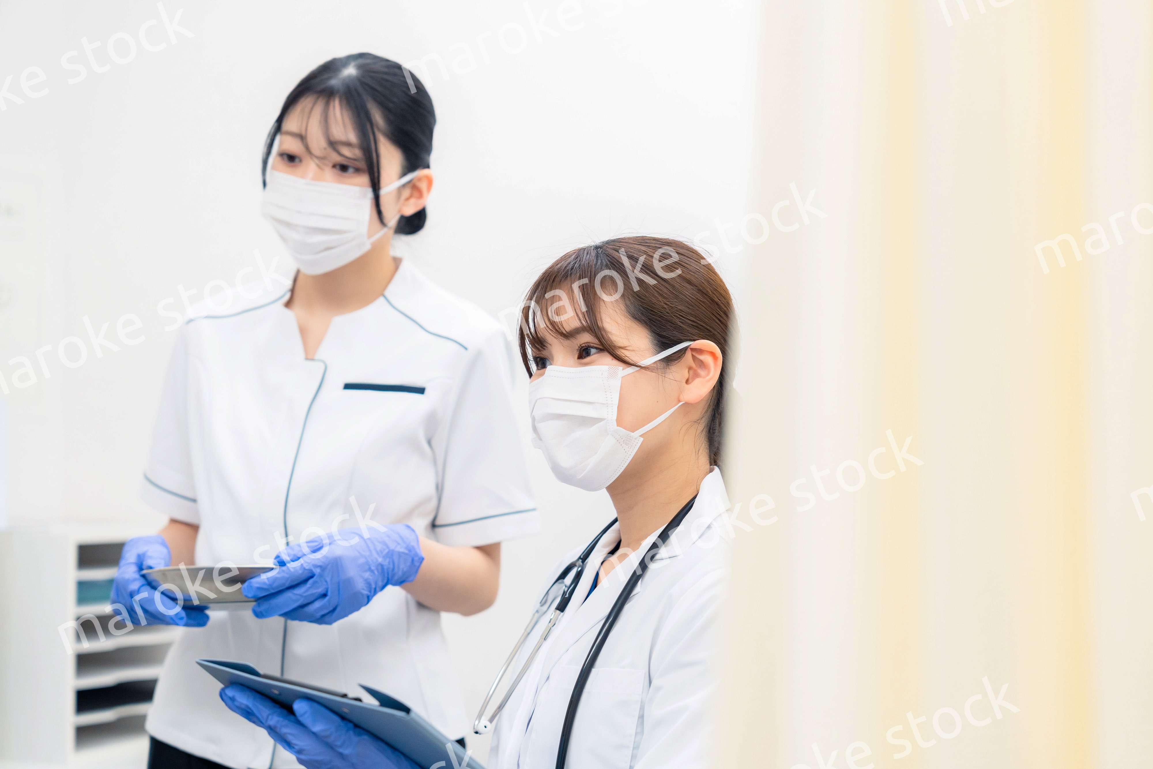 患者の治療をする2人の若い医療従事者