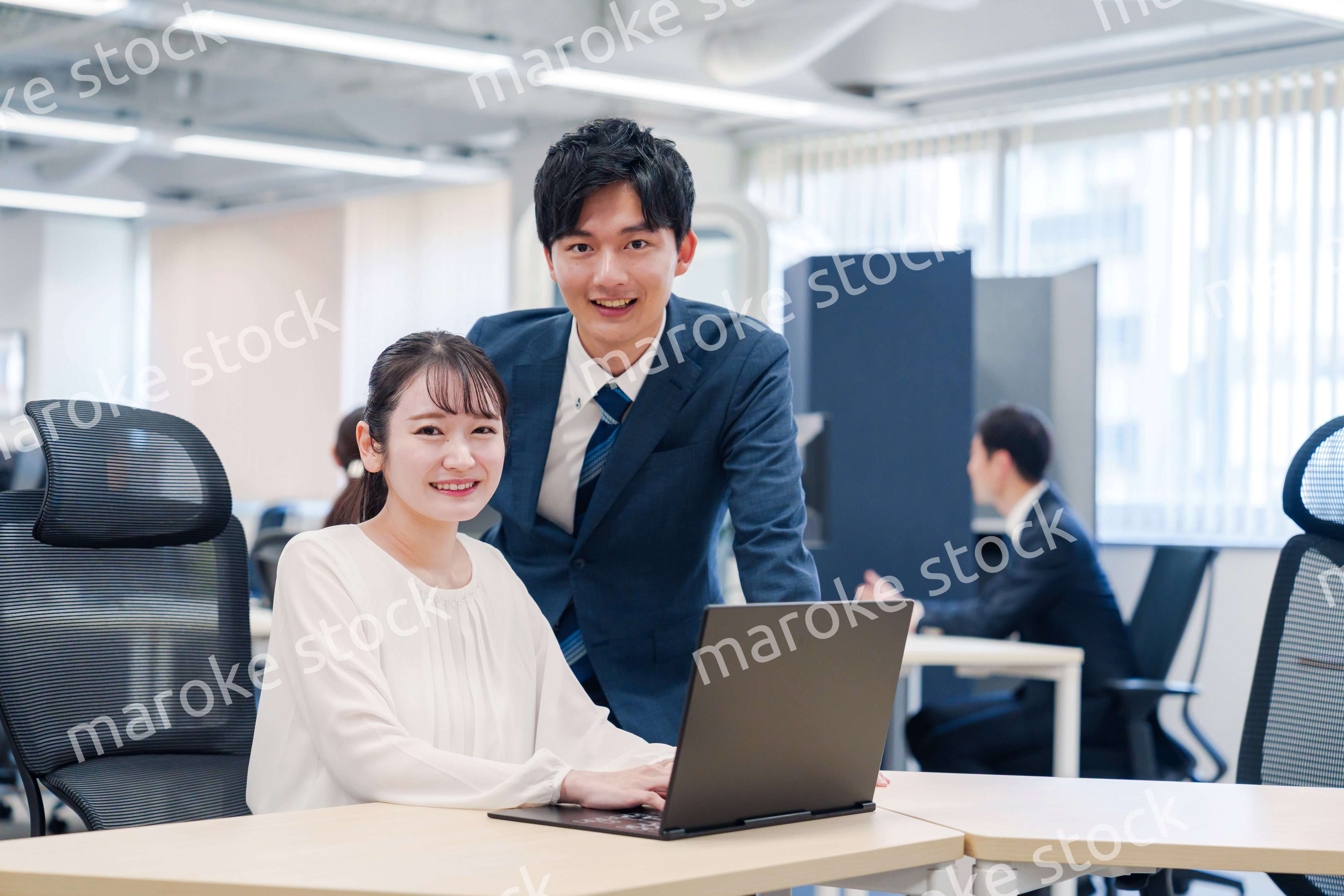 先輩社員から業務を教えてもらう新人の女性