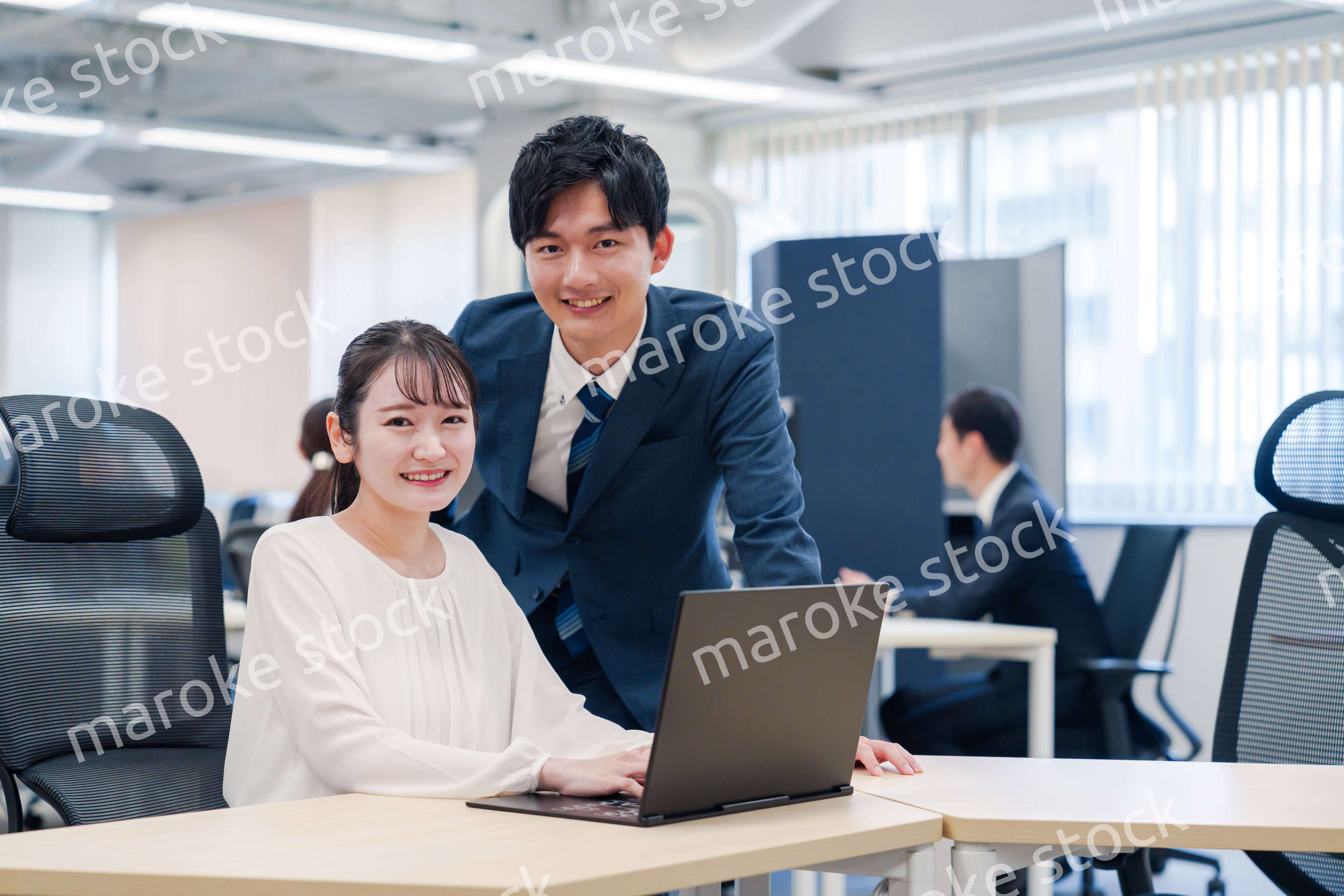 先輩社員から業務を教えてもらう新人の女性