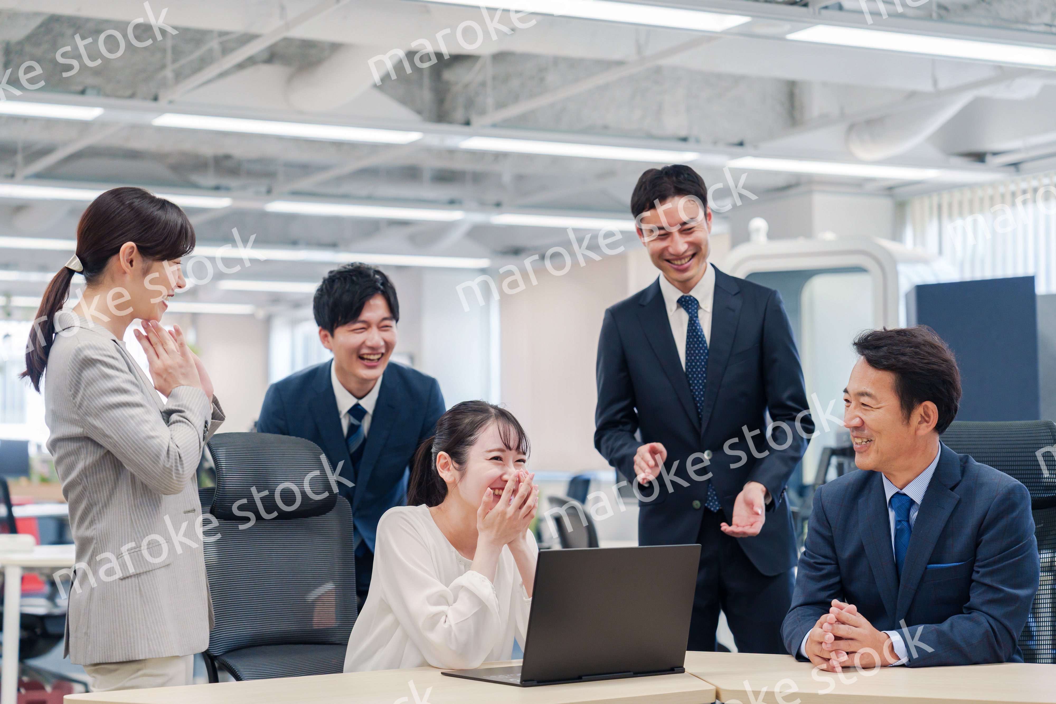 チームメンバーで非常ににこやかに仕事をするオフィスワーカー