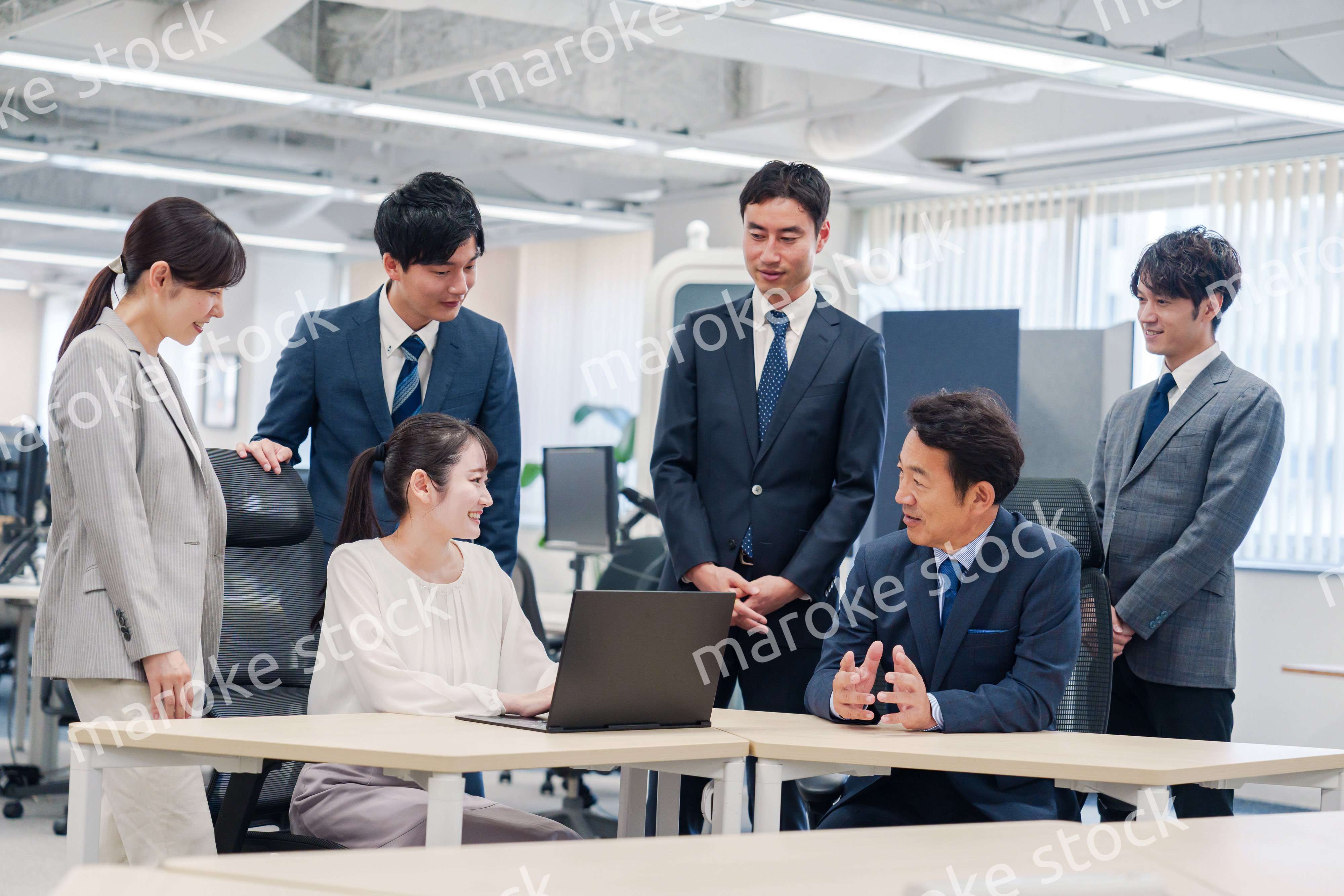 チームメンバーで非常ににこやかに仕事をするオフィスワーカー