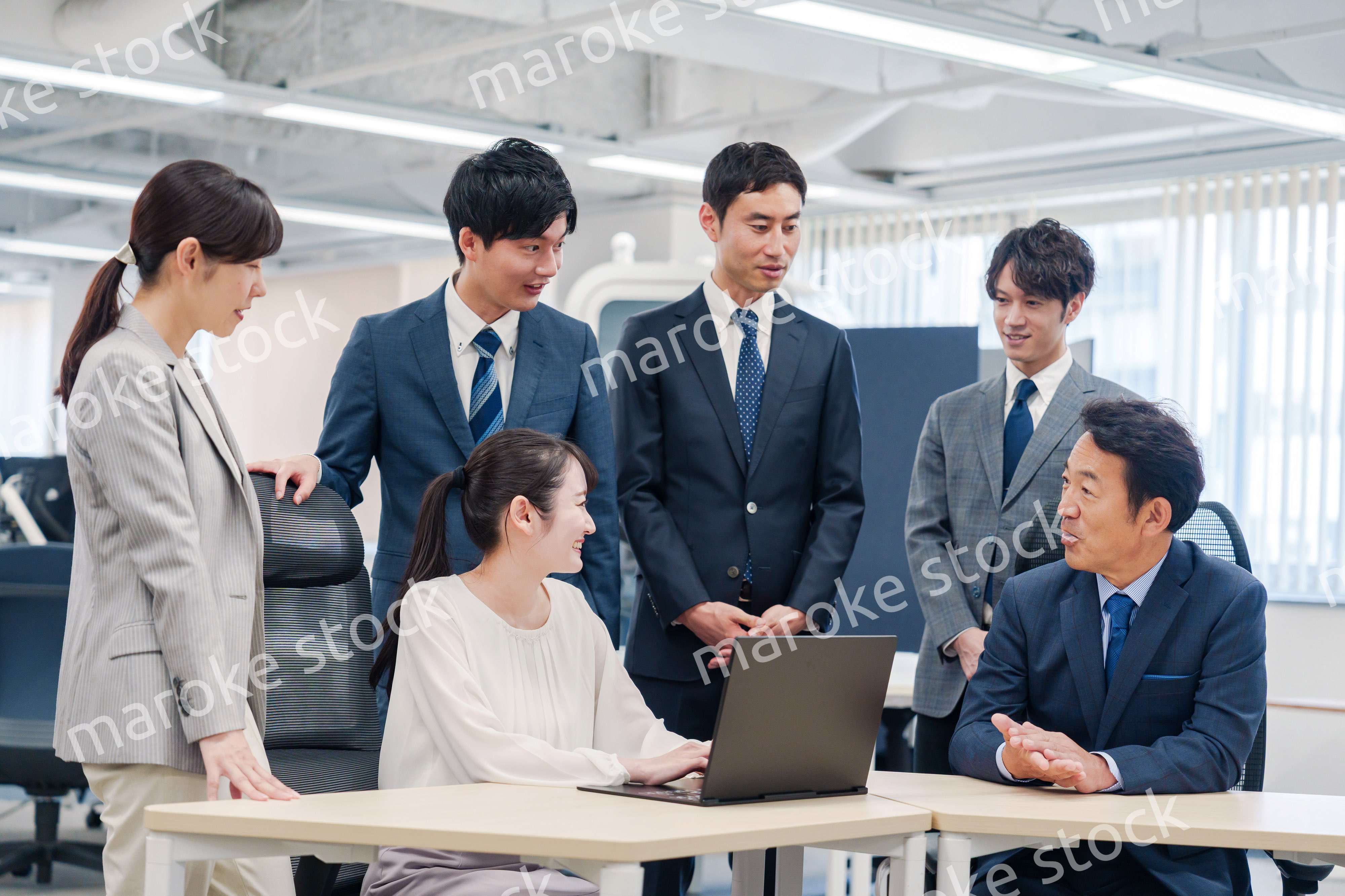 チームメンバーで非常ににこやかに仕事をするオフィスワーカー