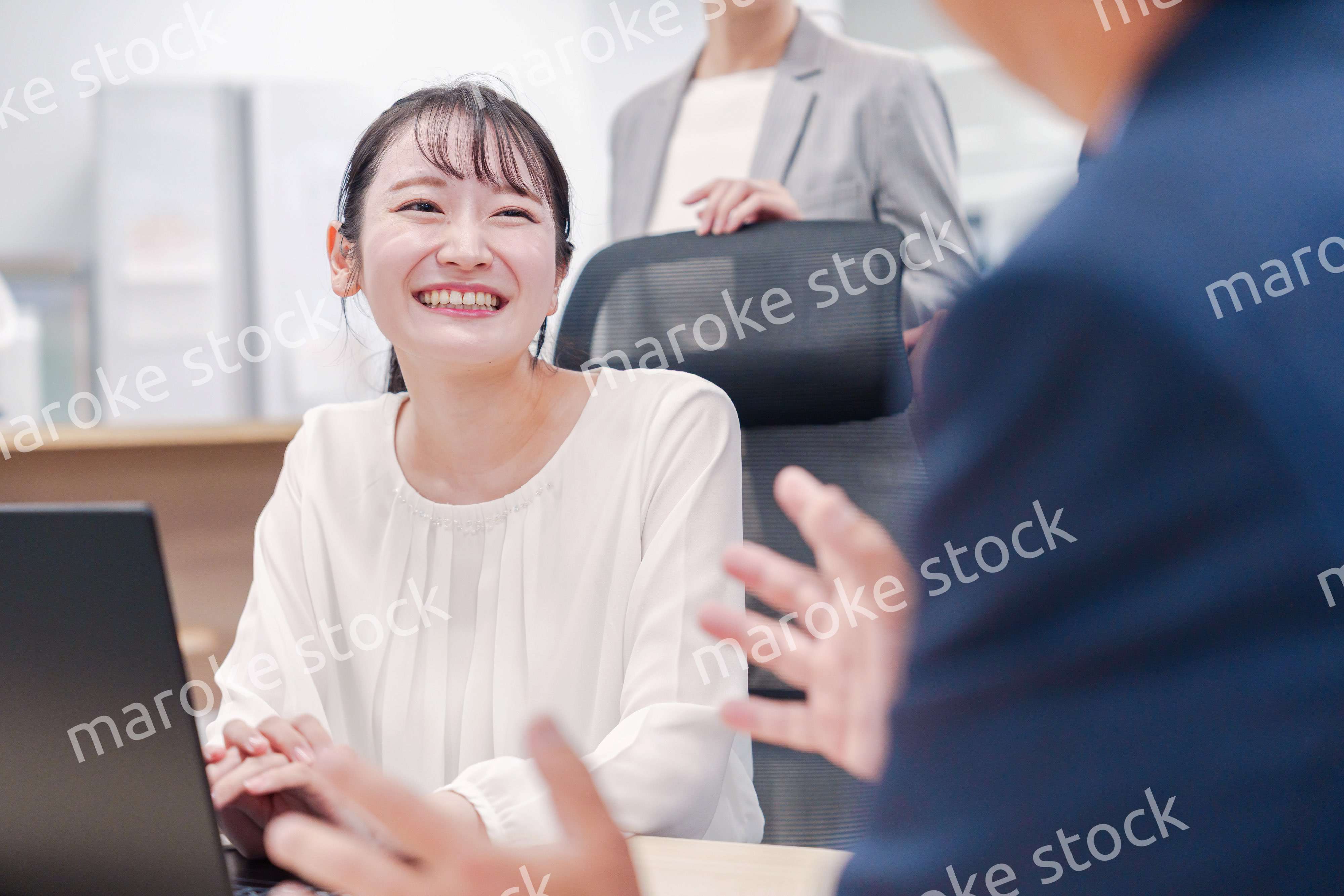 笑顔で上司の話を聞く若いビジネスウーマン