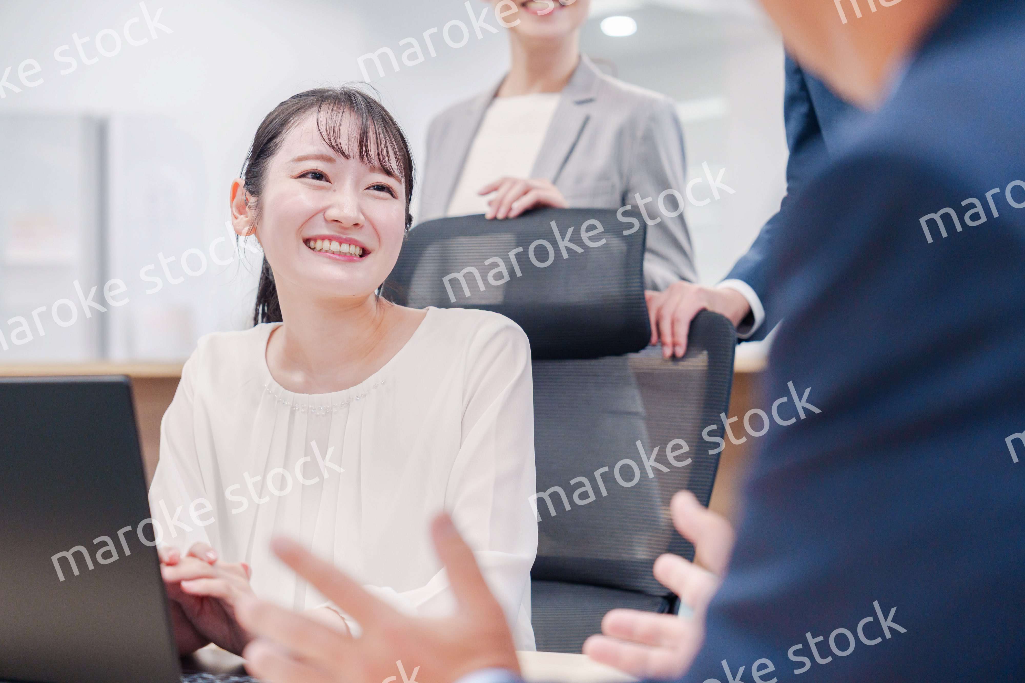 笑顔で上司の話を聞く若いビジネスウーマン