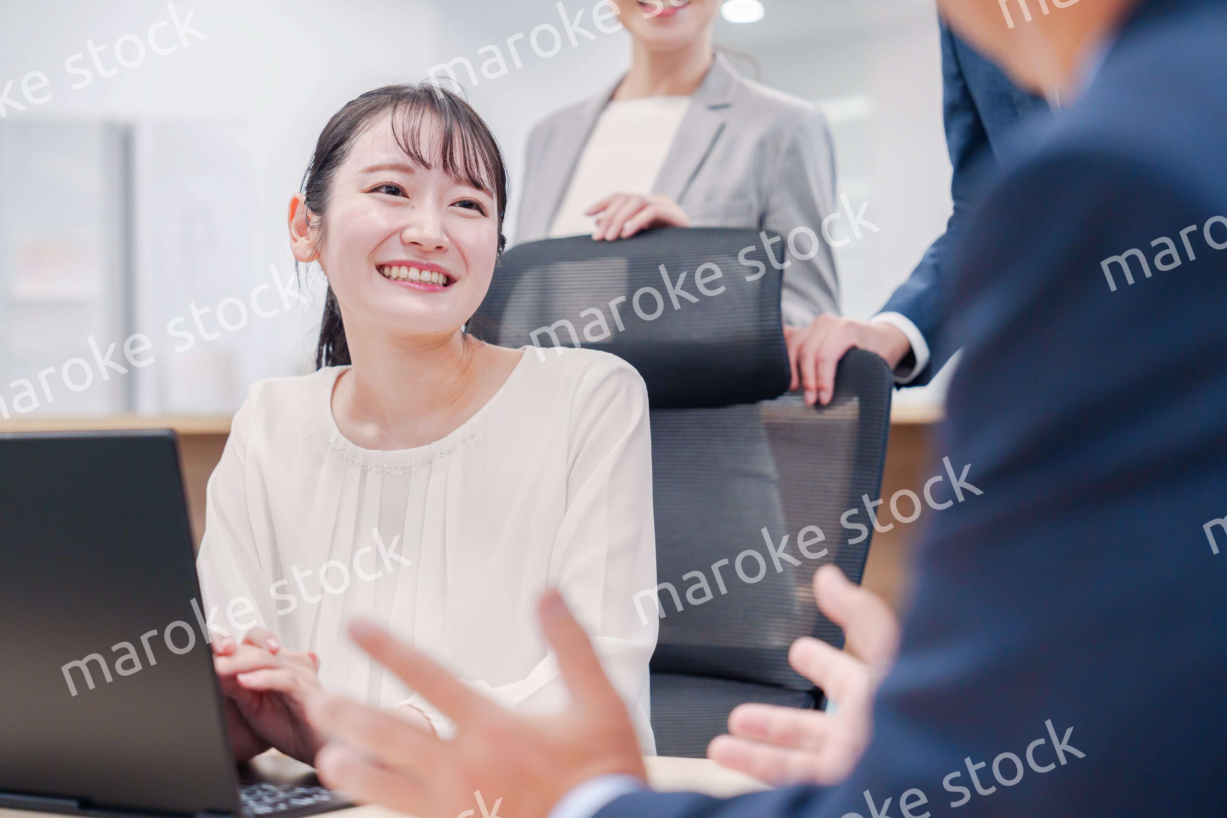 笑顔で上司の話を聞く若いビジネスウーマン