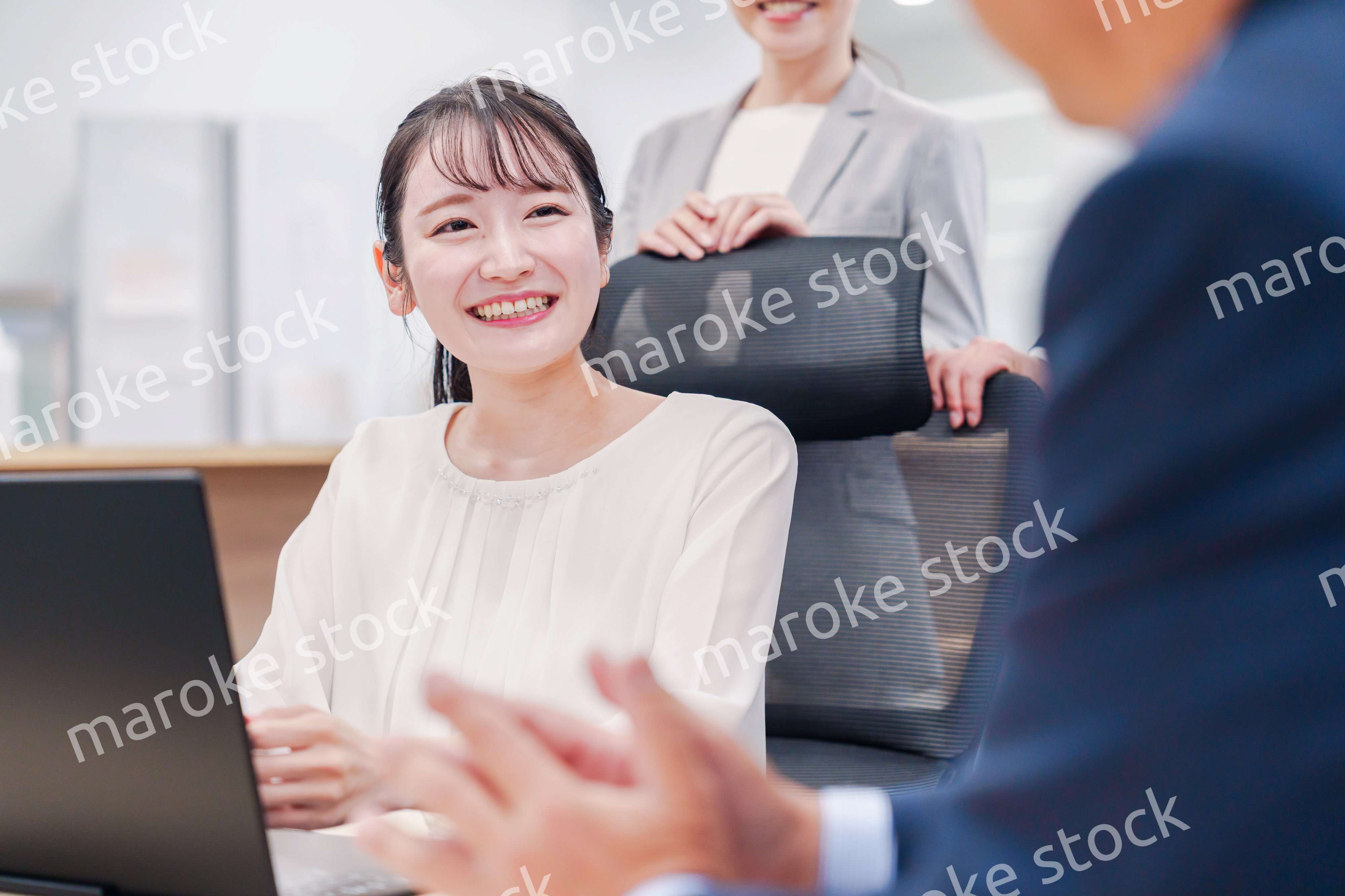 笑顔で上司の話を聞く若いビジネスウーマン