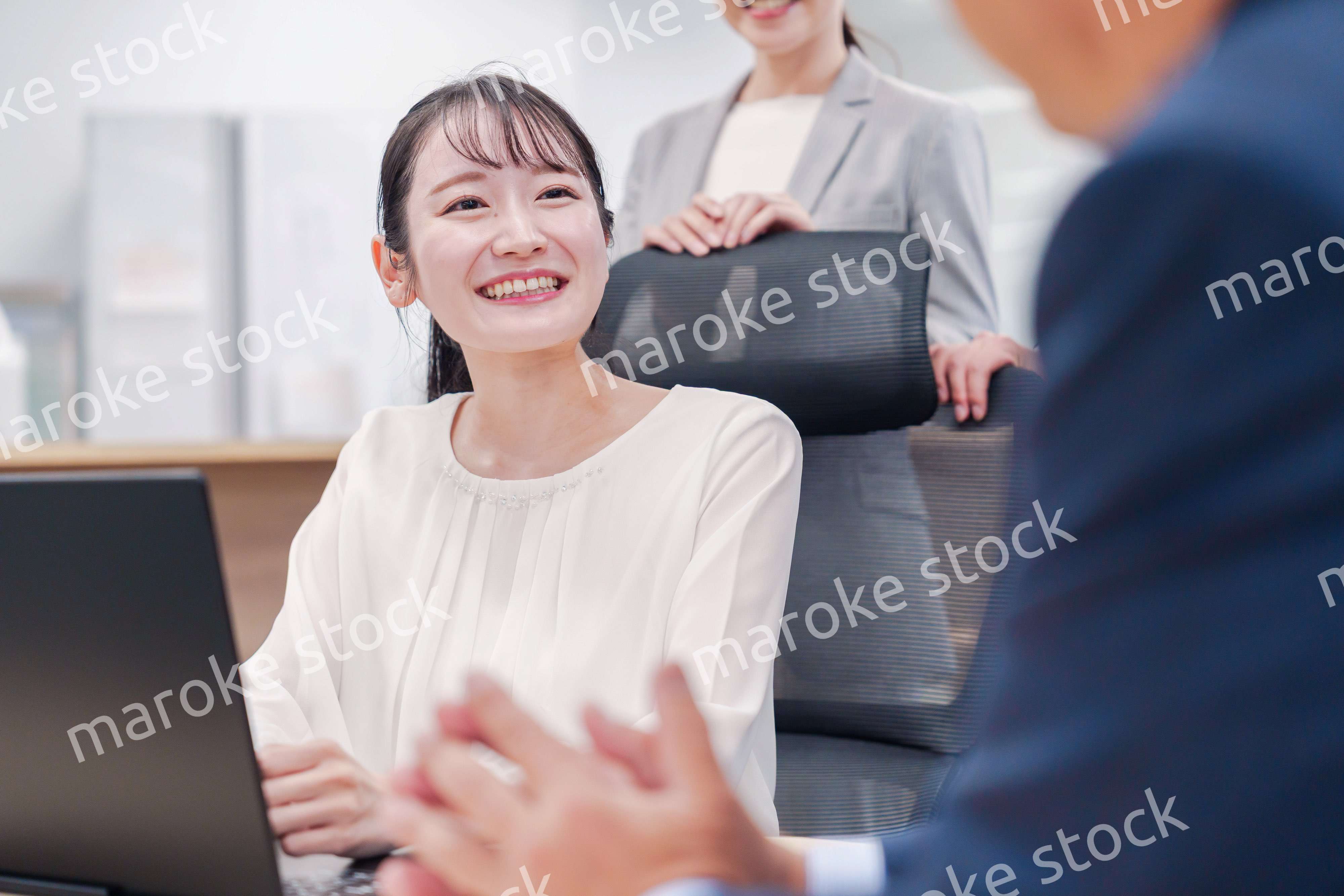 笑顔で上司の話を聞く若いビジネスウーマン