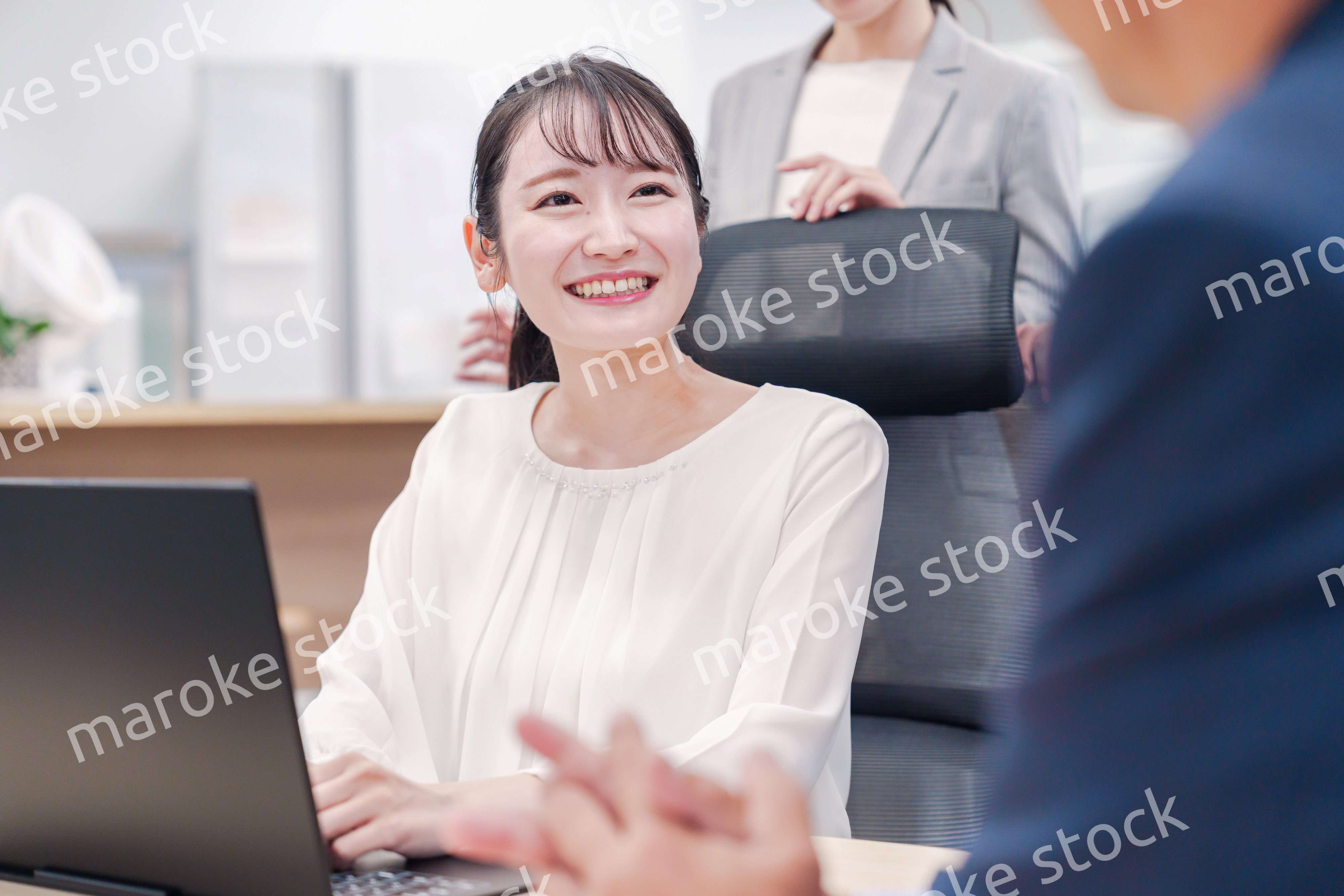 笑顔で上司の話を聞く若いビジネスウーマン