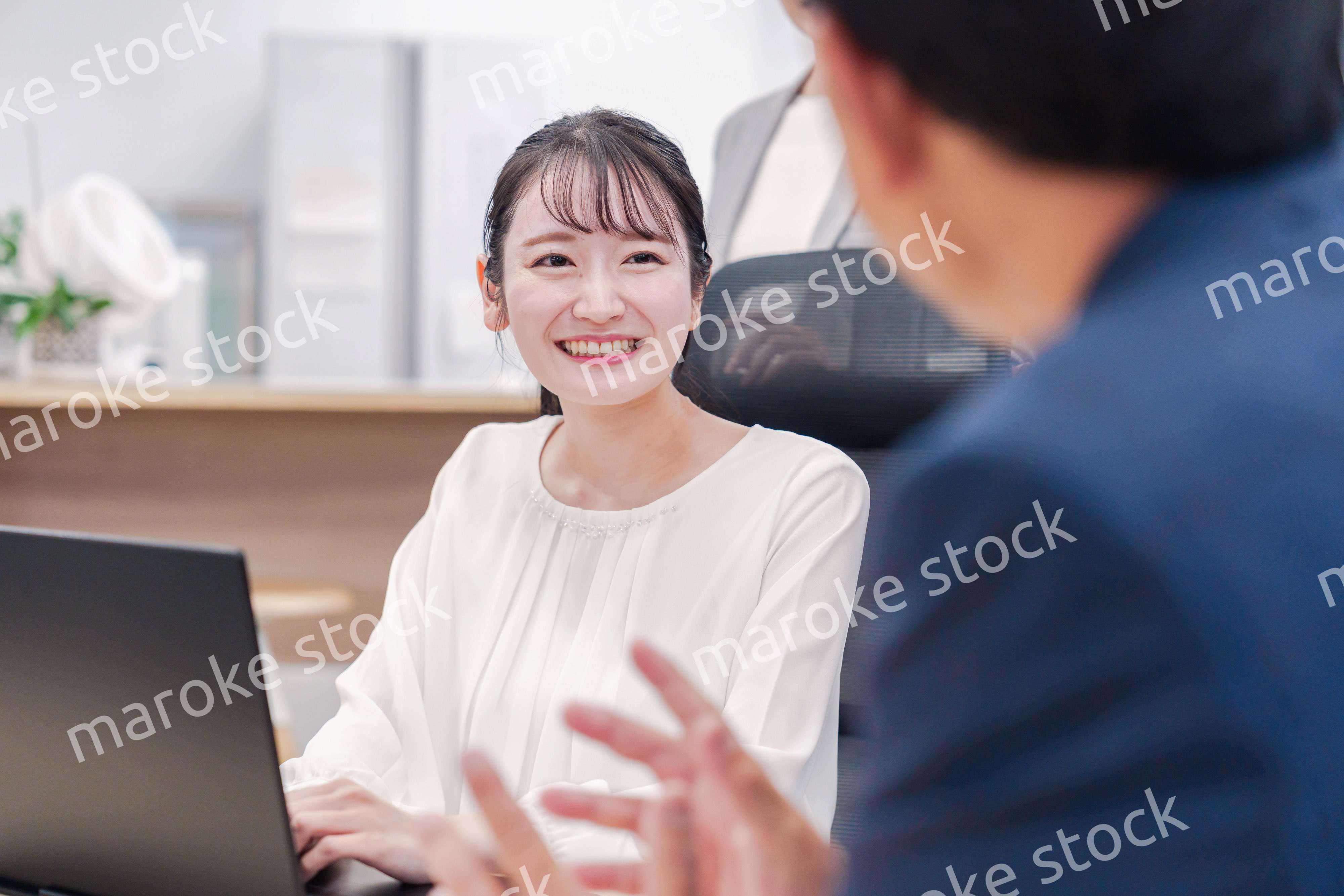 笑顔で上司の話を聞く若いビジネスウーマン