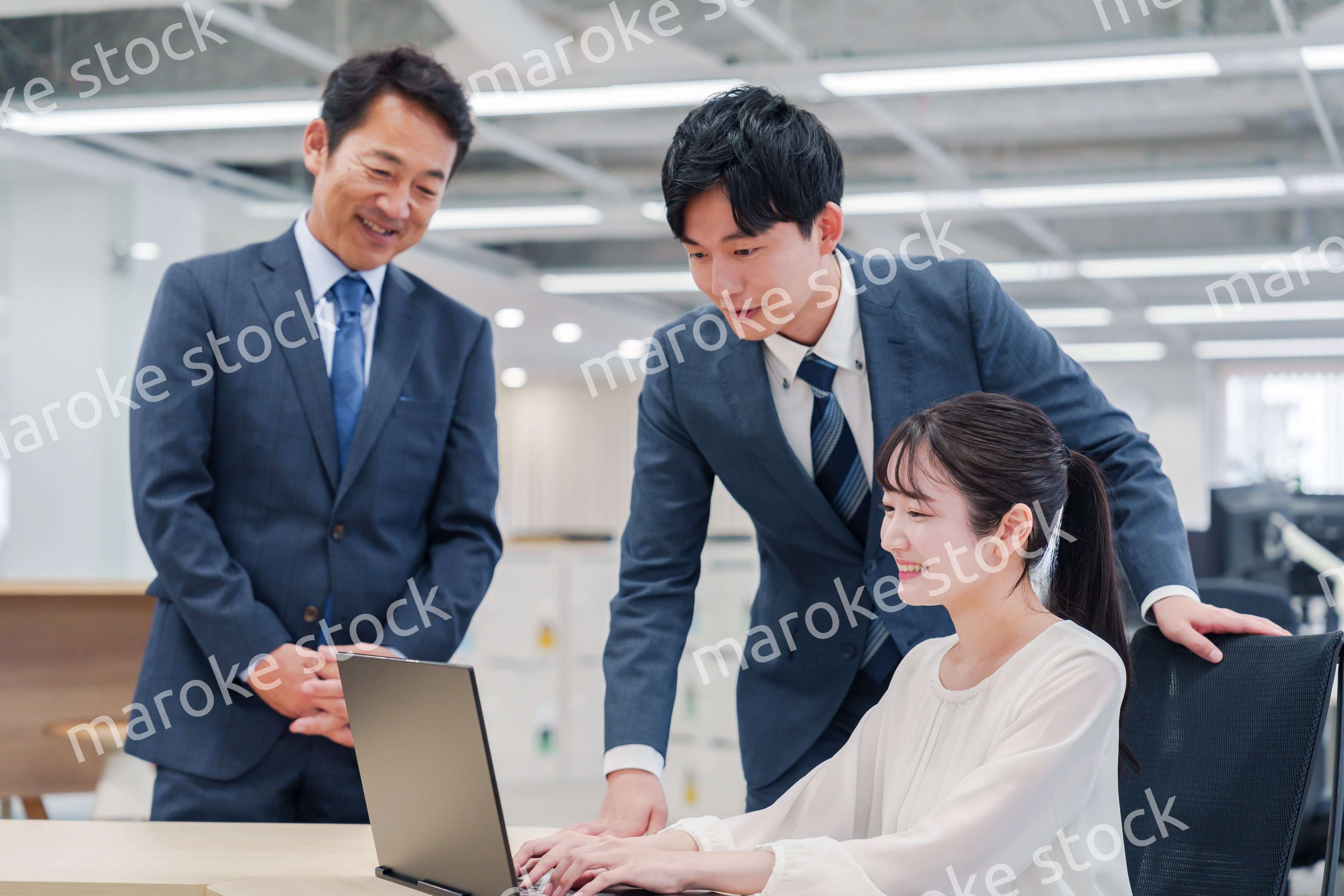 オフィスのデスクで打ち合わせをする男女のビジネスパーソン