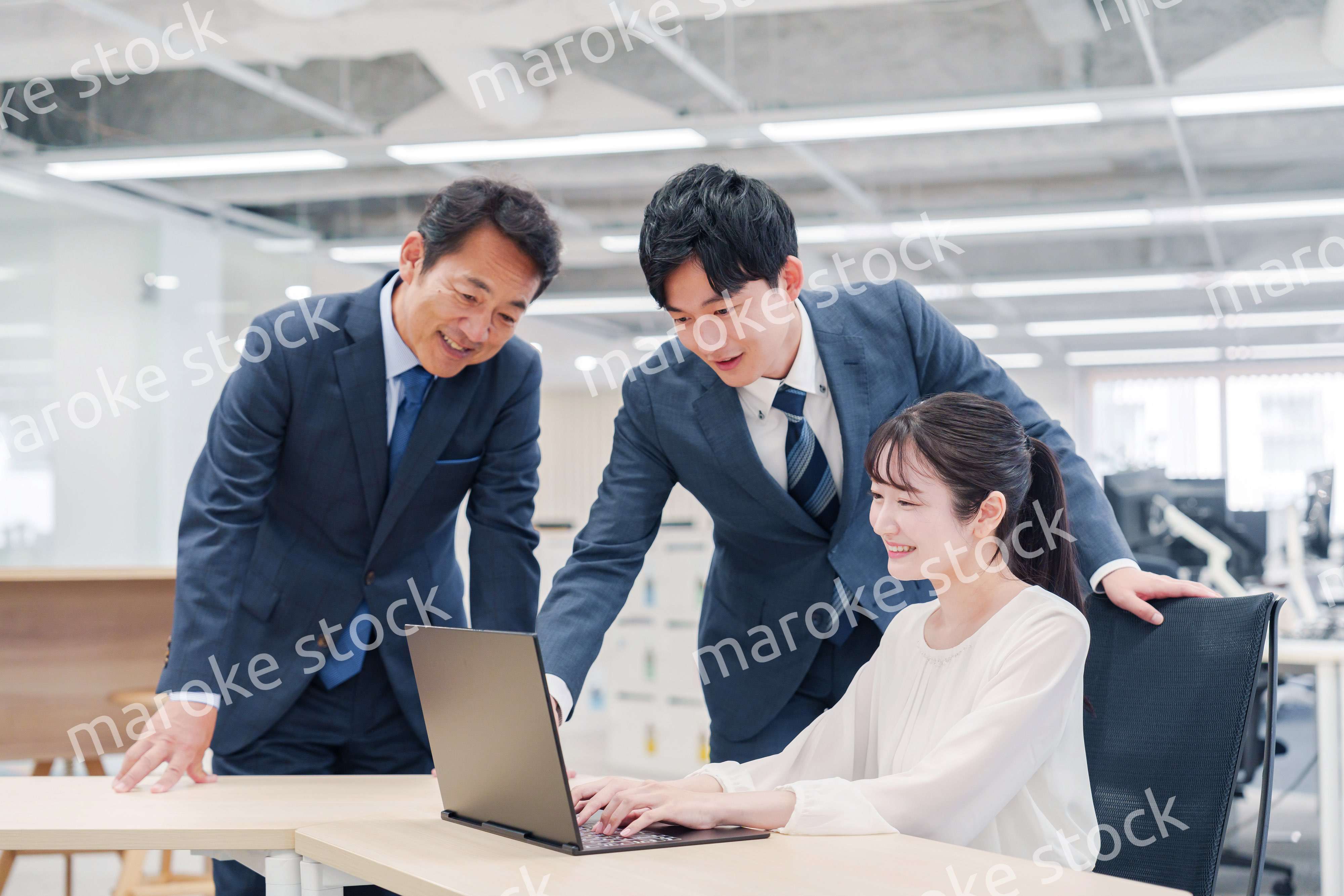 オフィスのデスクで打ち合わせをする男女のビジネスパーソン