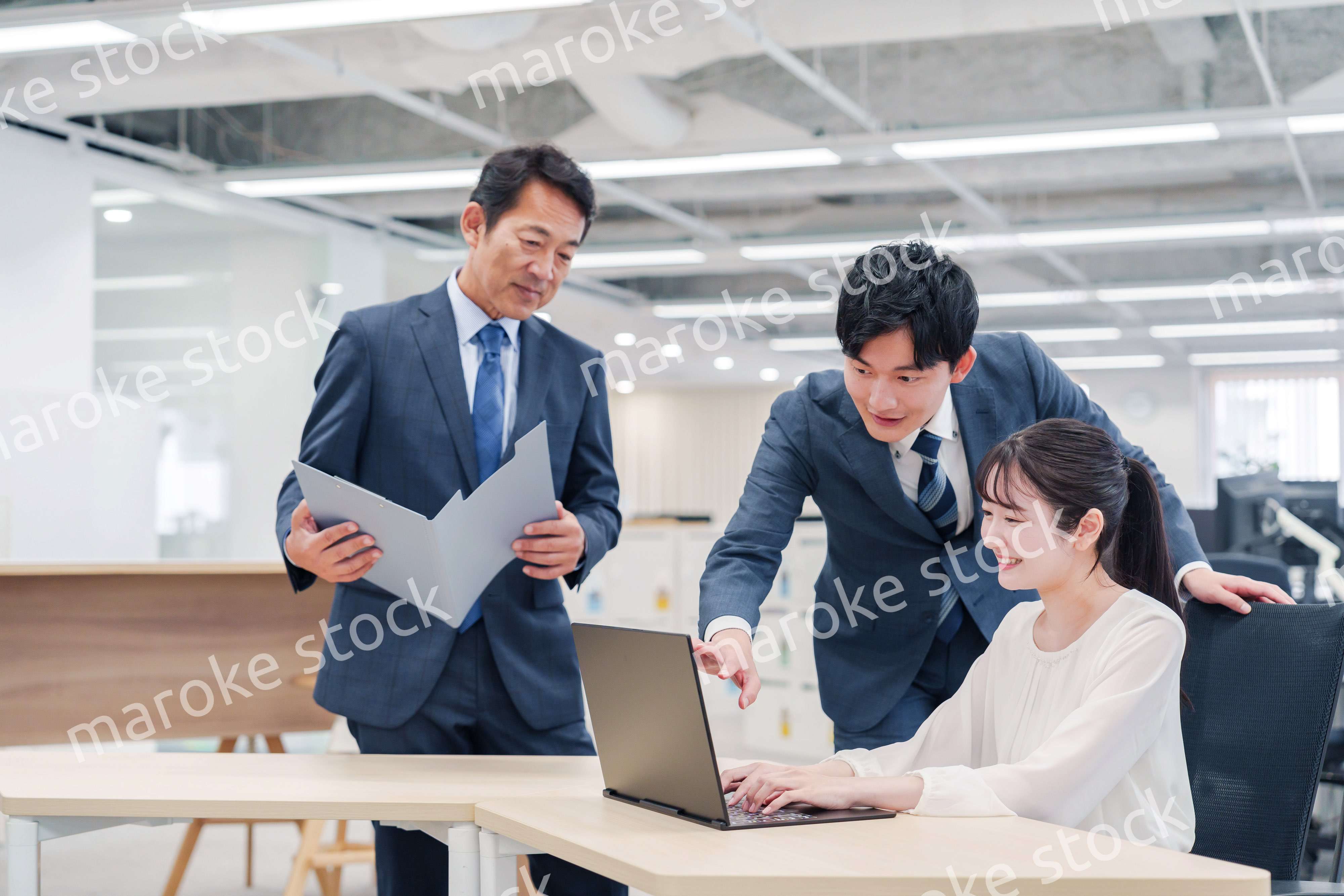 オフィスのデスクで打ち合わせをする男女のビジネスパーソン