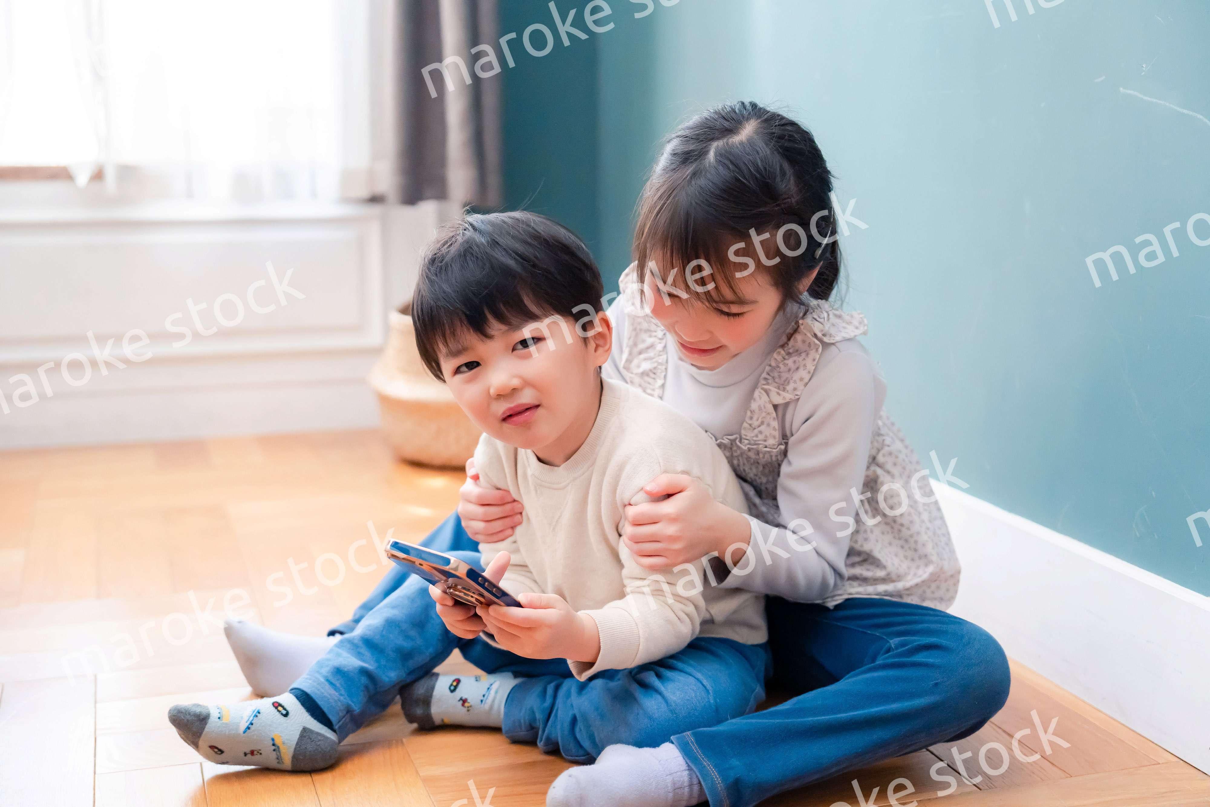 兄弟でスマホを取り合う小さな子ども