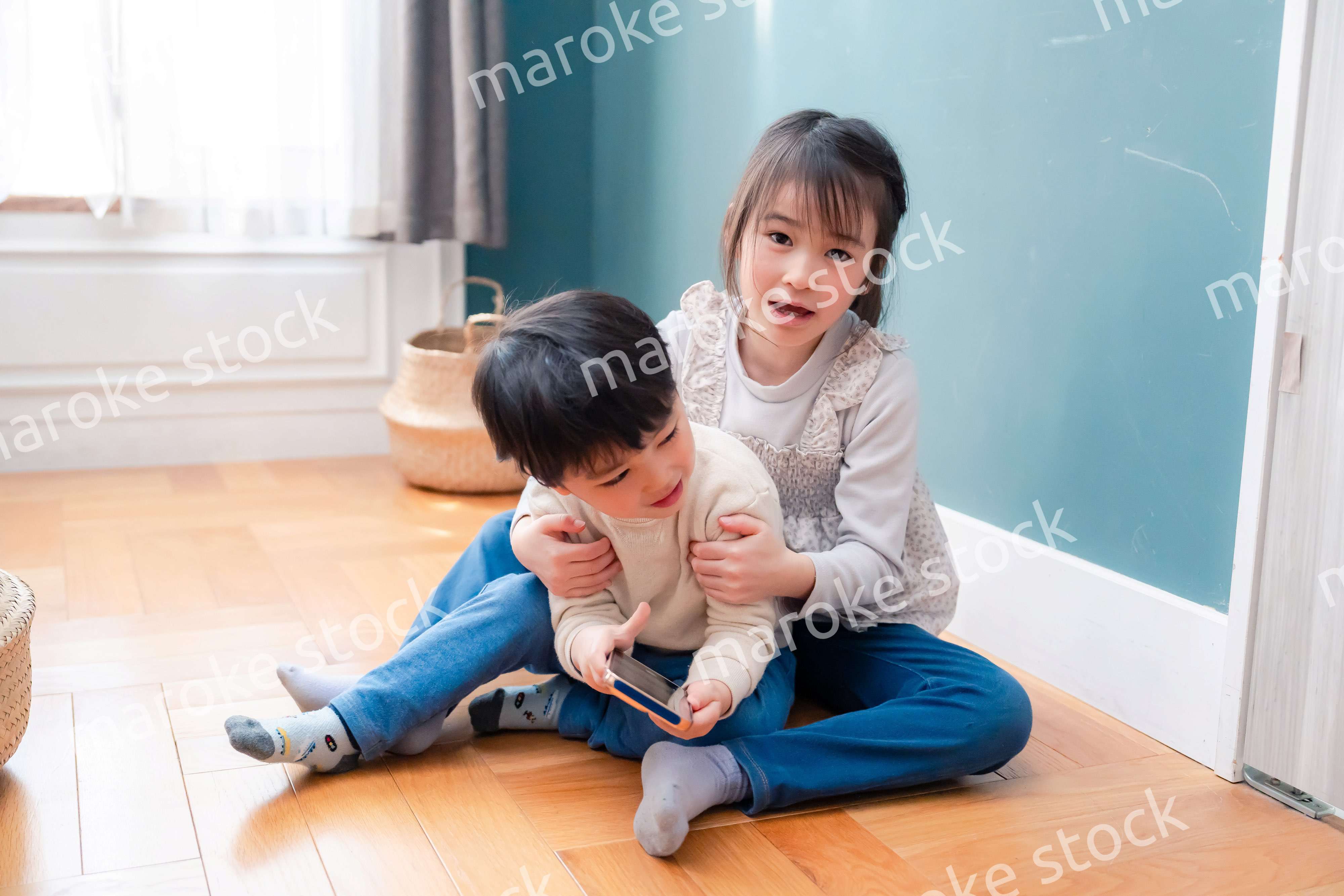 兄弟でスマホを取り合う小さな子ども