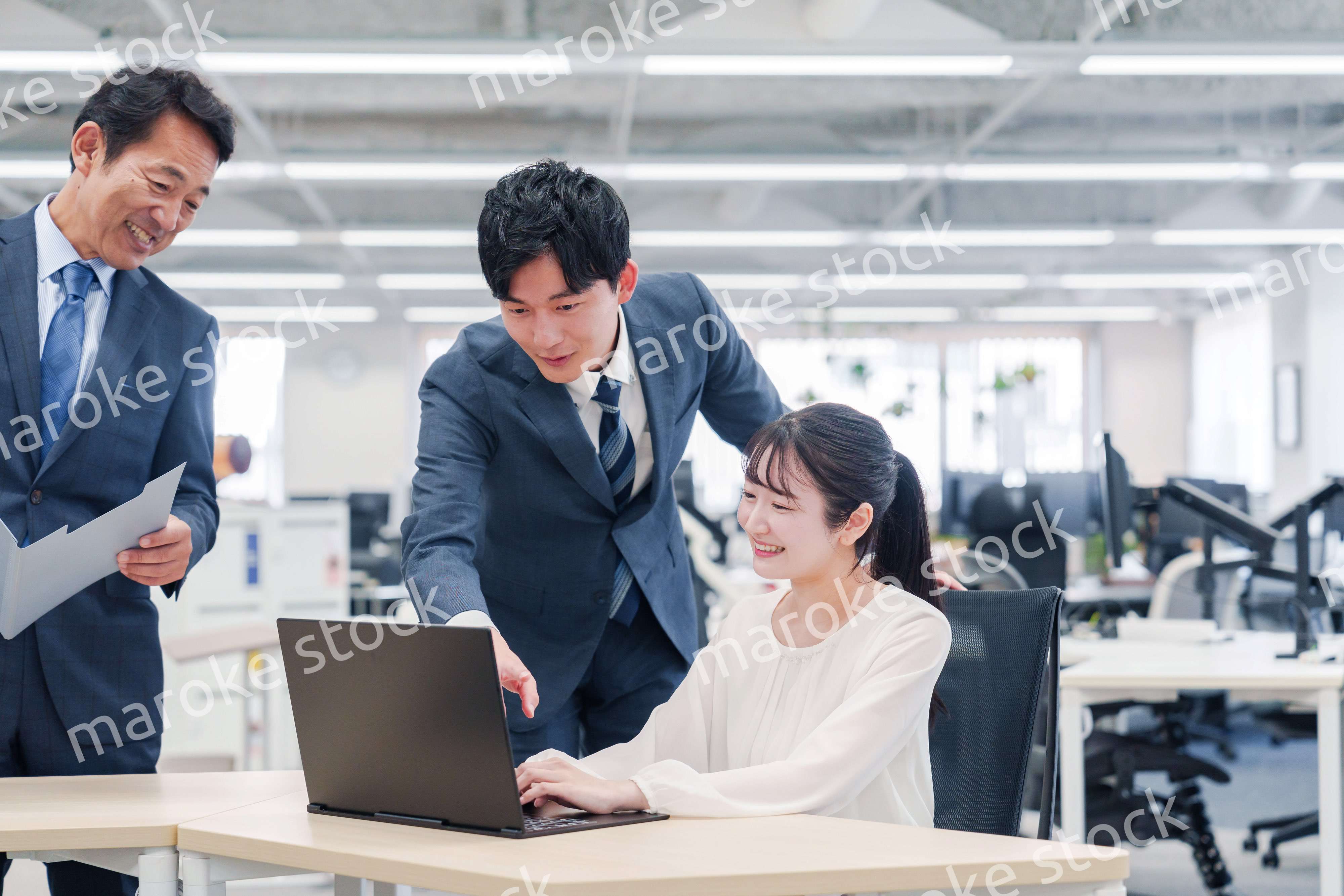 オフィスのデスクで打ち合わせをする男女のビジネスパーソン