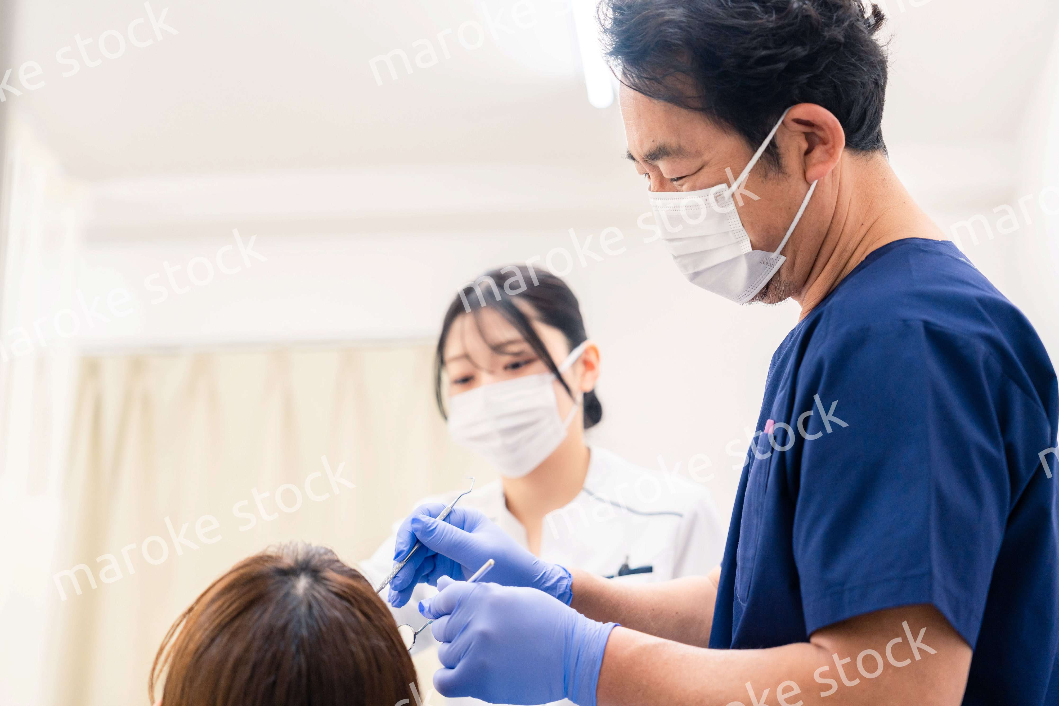 歯科治療をする歯医者の男性