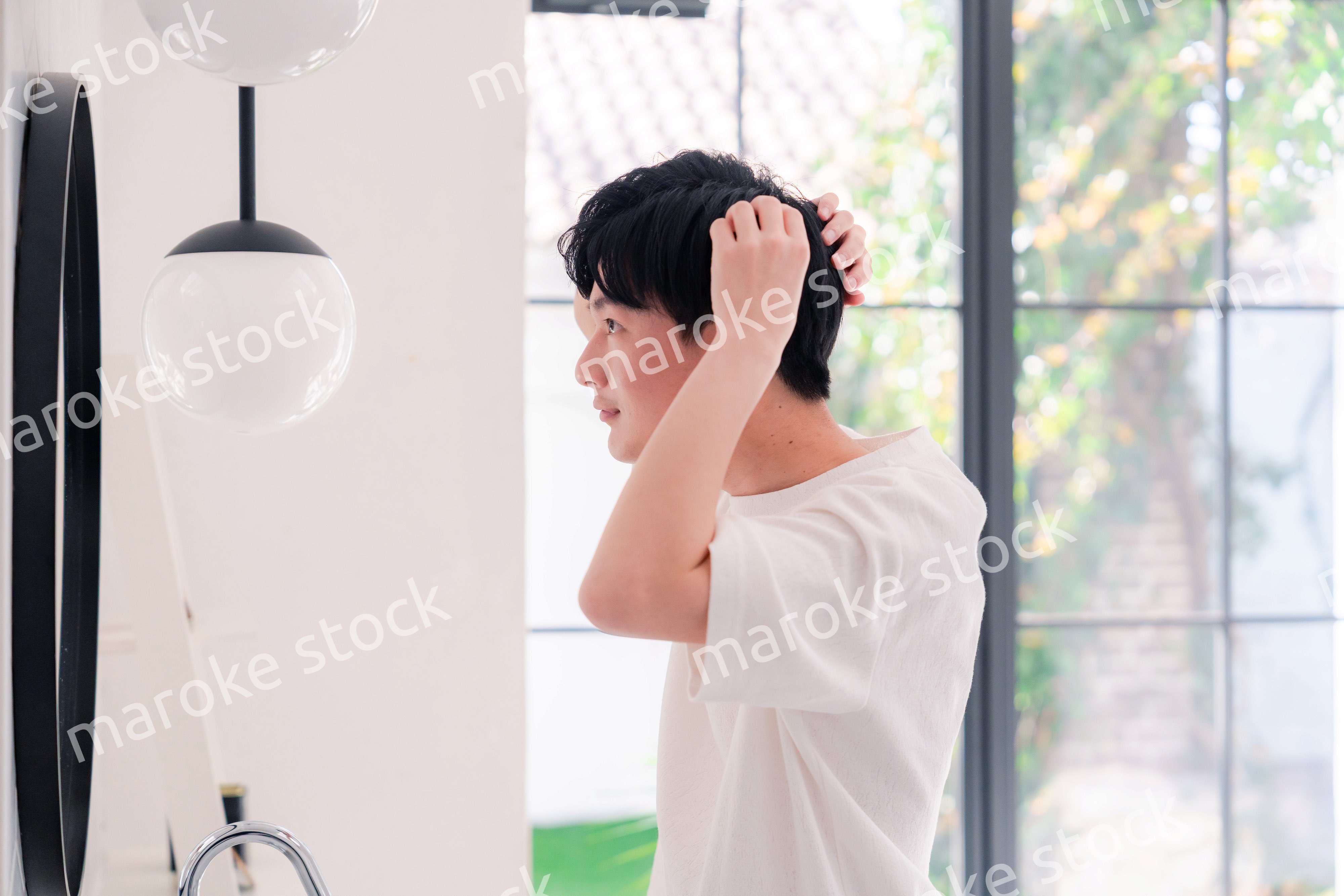 洗面所で身だしなみを整える若い男性