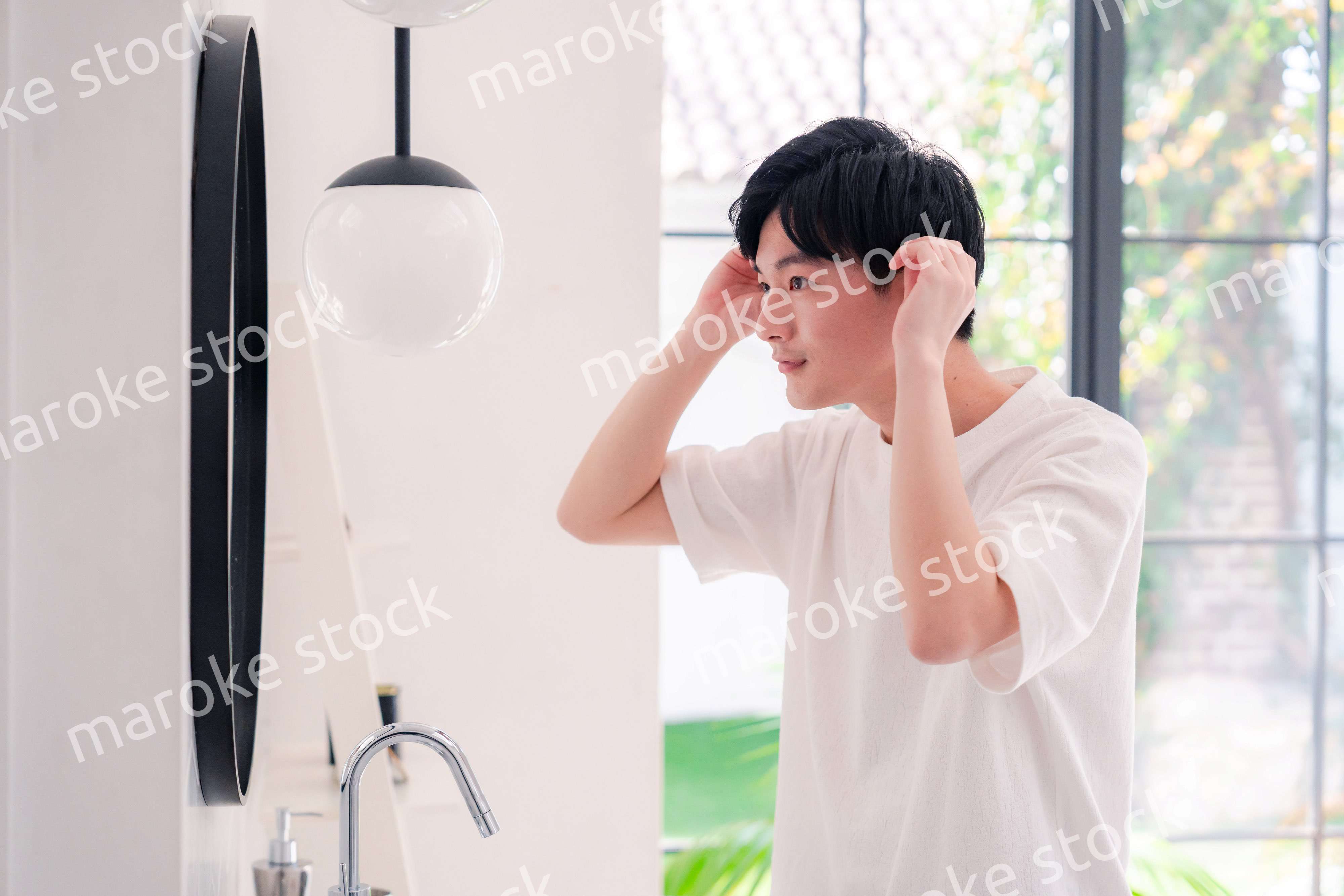 洗面所で身だしなみを整える若い男性