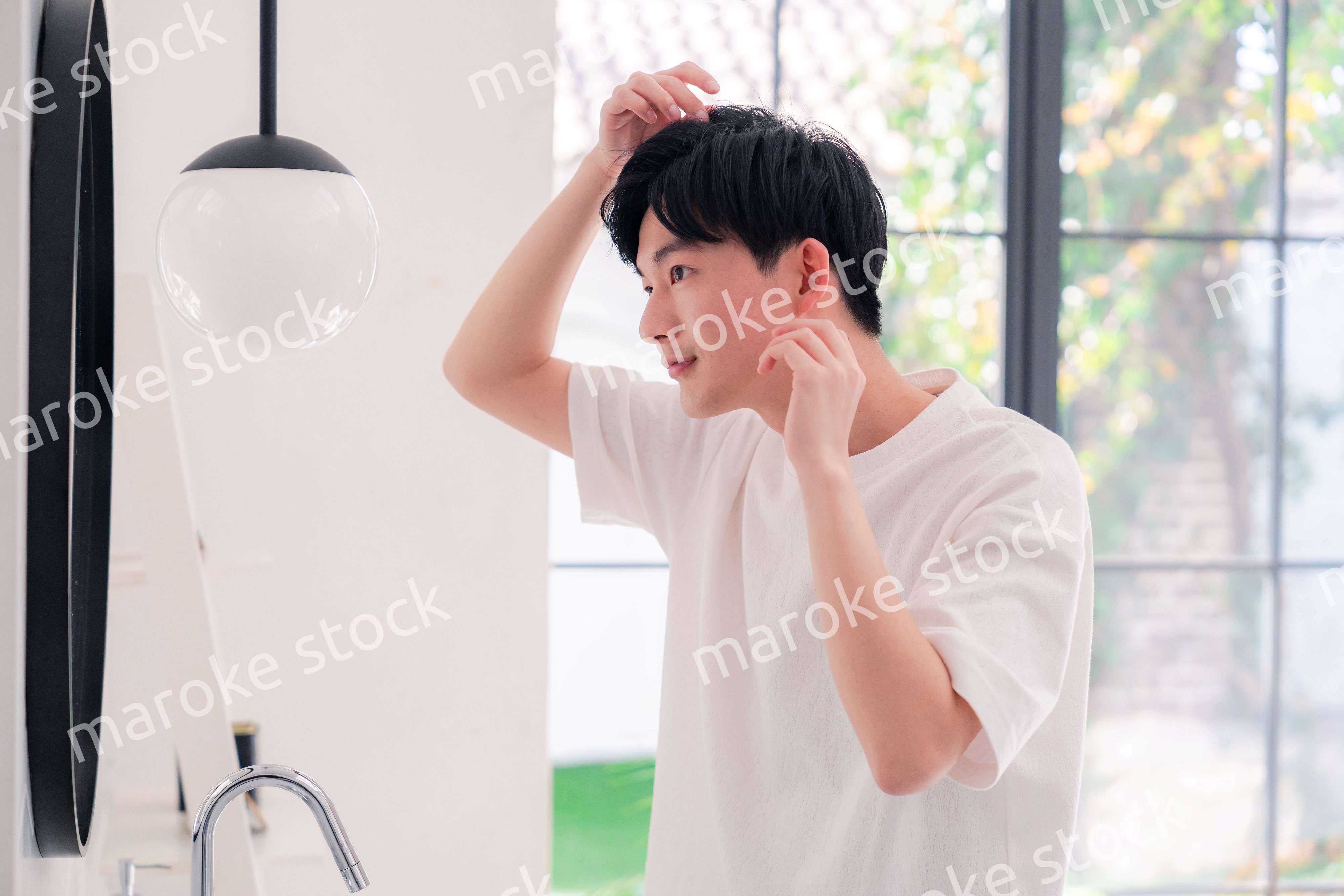 洗面所で身だしなみを整える若い男性